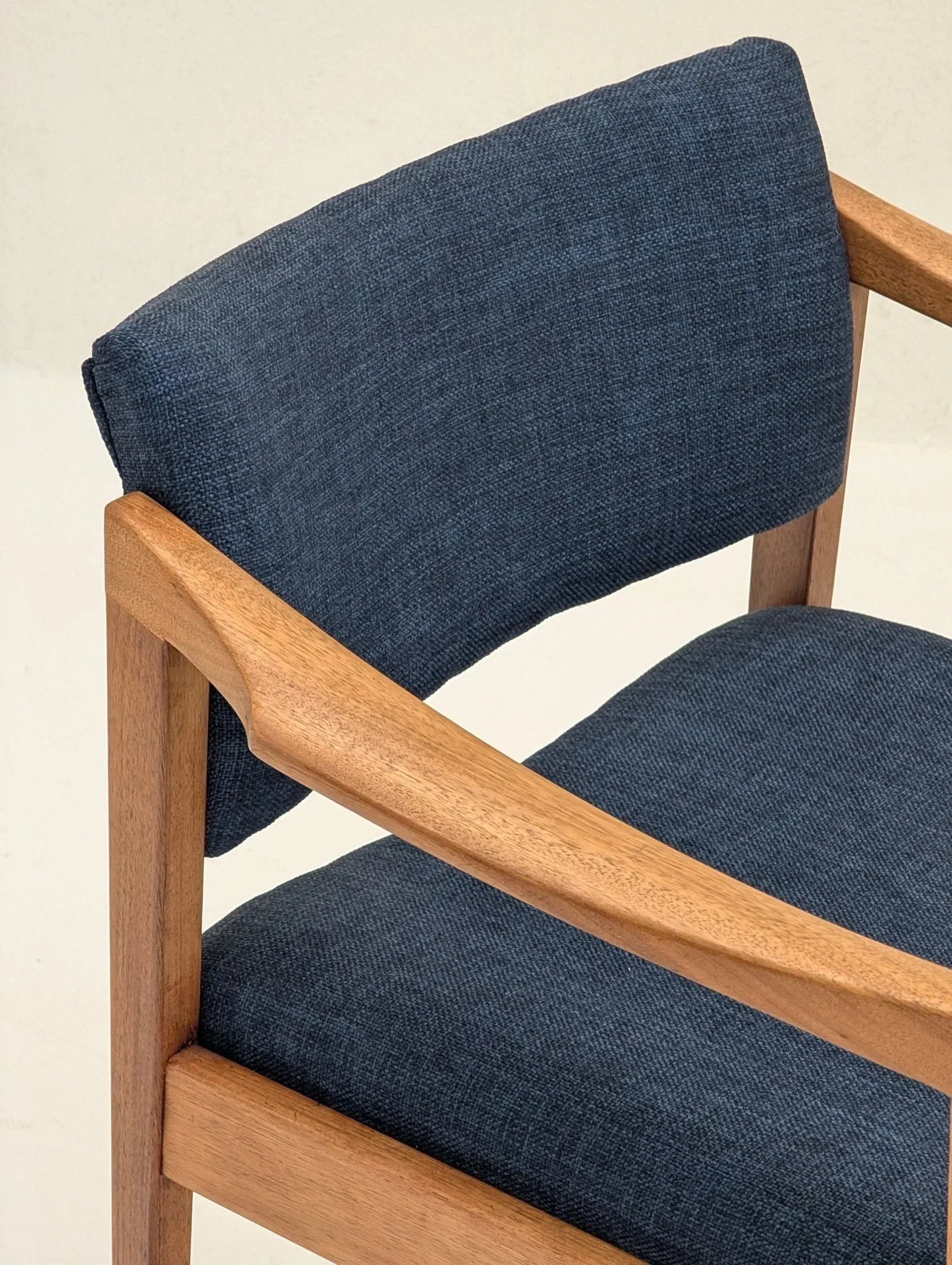 Mid-century modern armchair with wood frame and blue fabric upholstery
