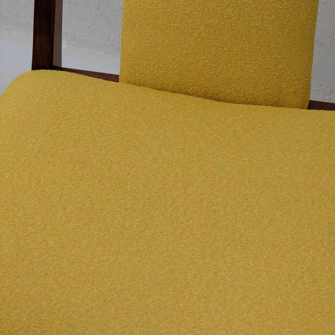 Close-up of yellow mid-century modern dining chair upholstery with wood frame