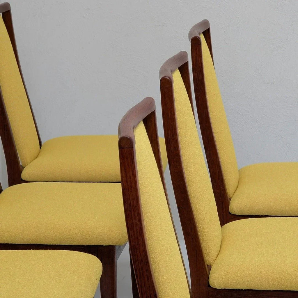 Mid-century modern dining chairs with yellow upholstery and wooden frames