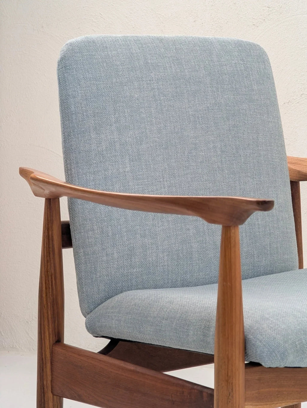 Mid-century modern teak armchair with light blue fabric and sculptural wooden frame