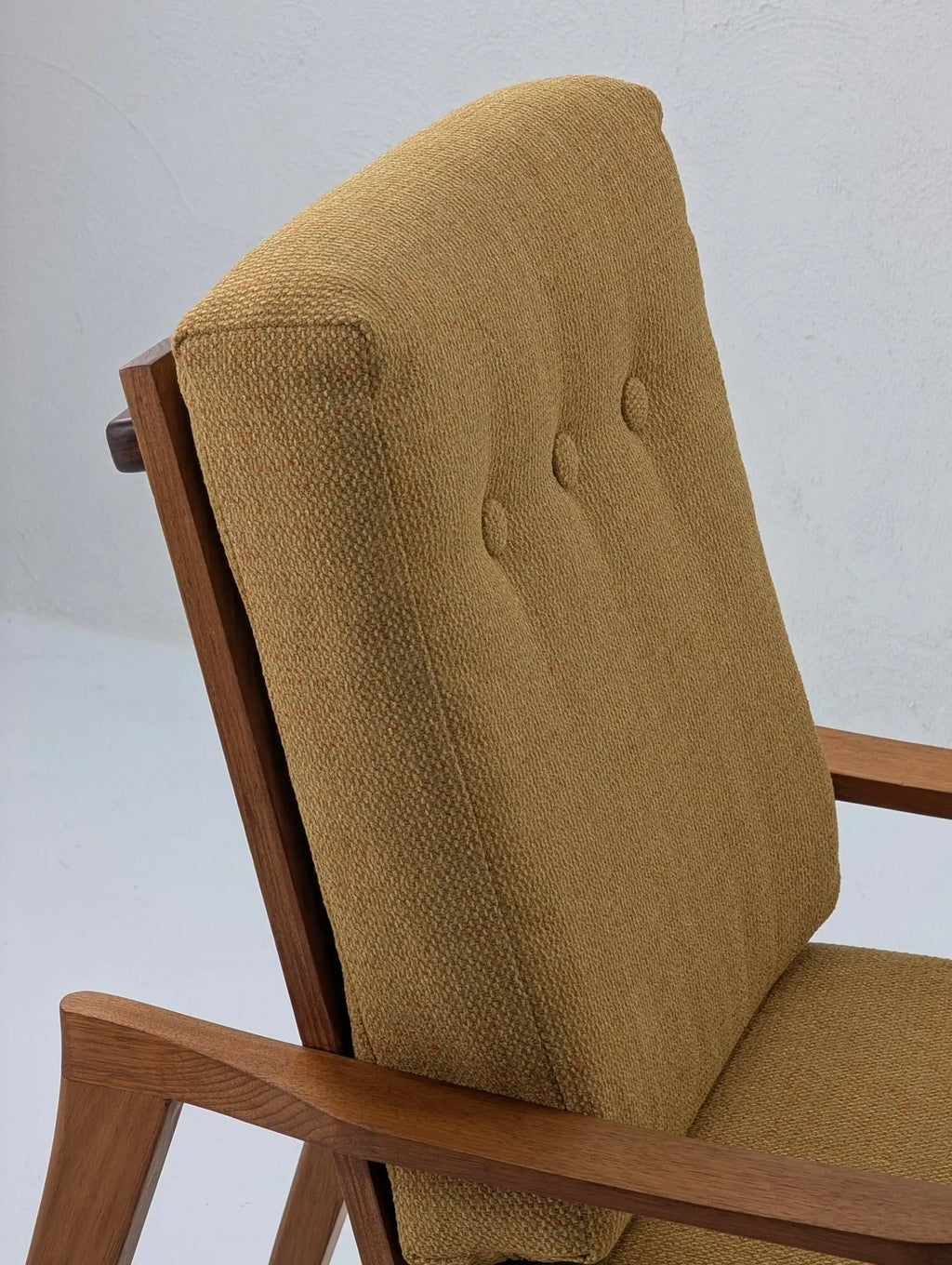 Mid-century modern solid teak lounge chair with textured tan upholstery and button tufting