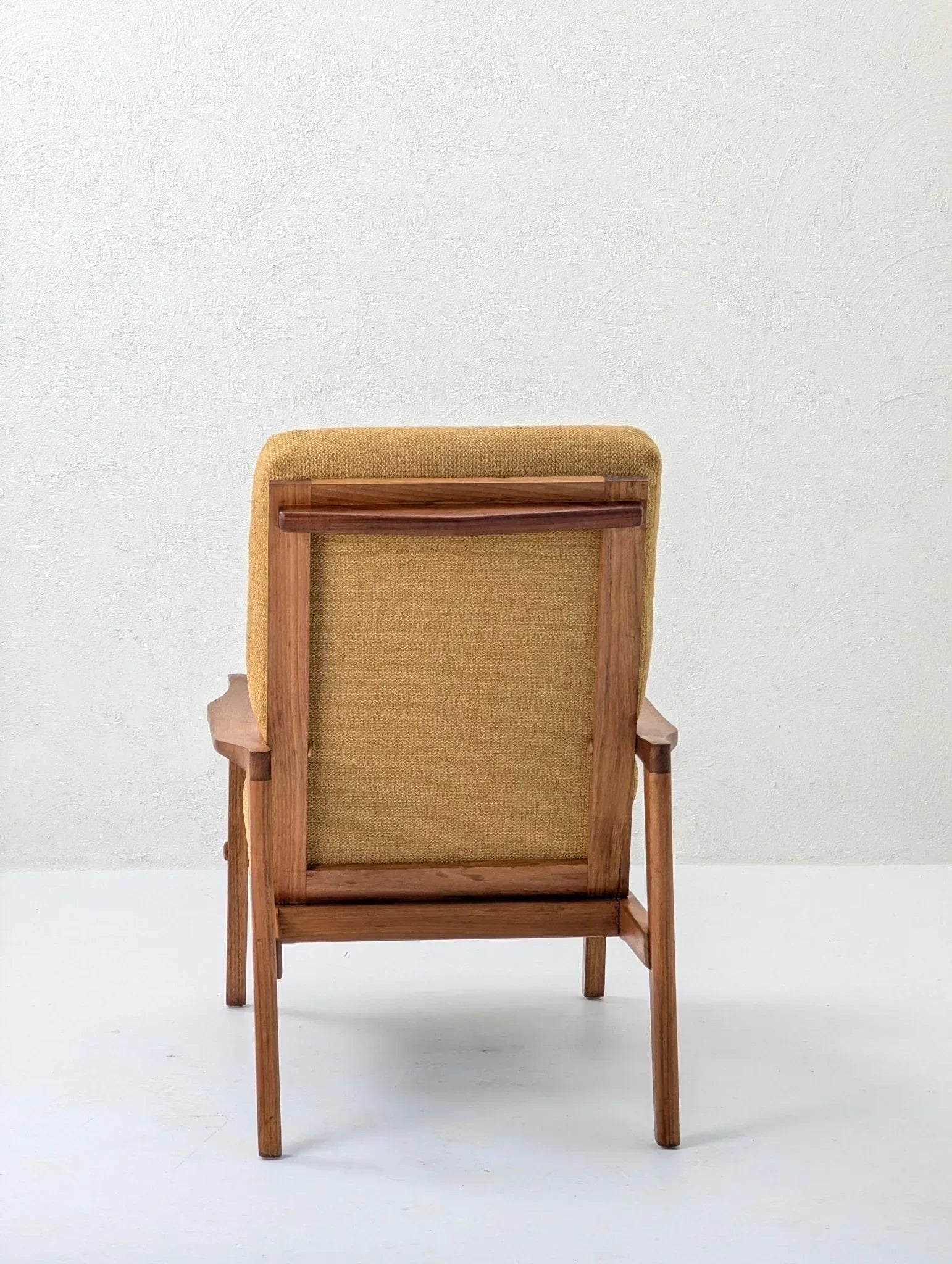 mid-century modern solid teak lounge chair with beige upholstery, rear view