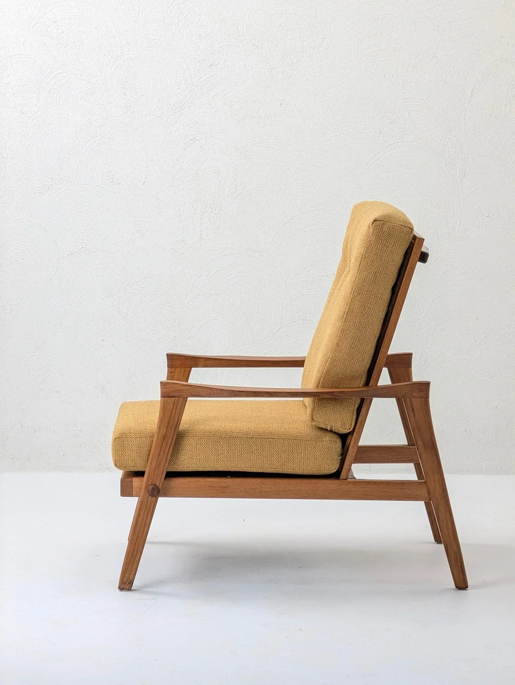 Mid-century modern solid teak lounge chair with mustard upholstery, white background