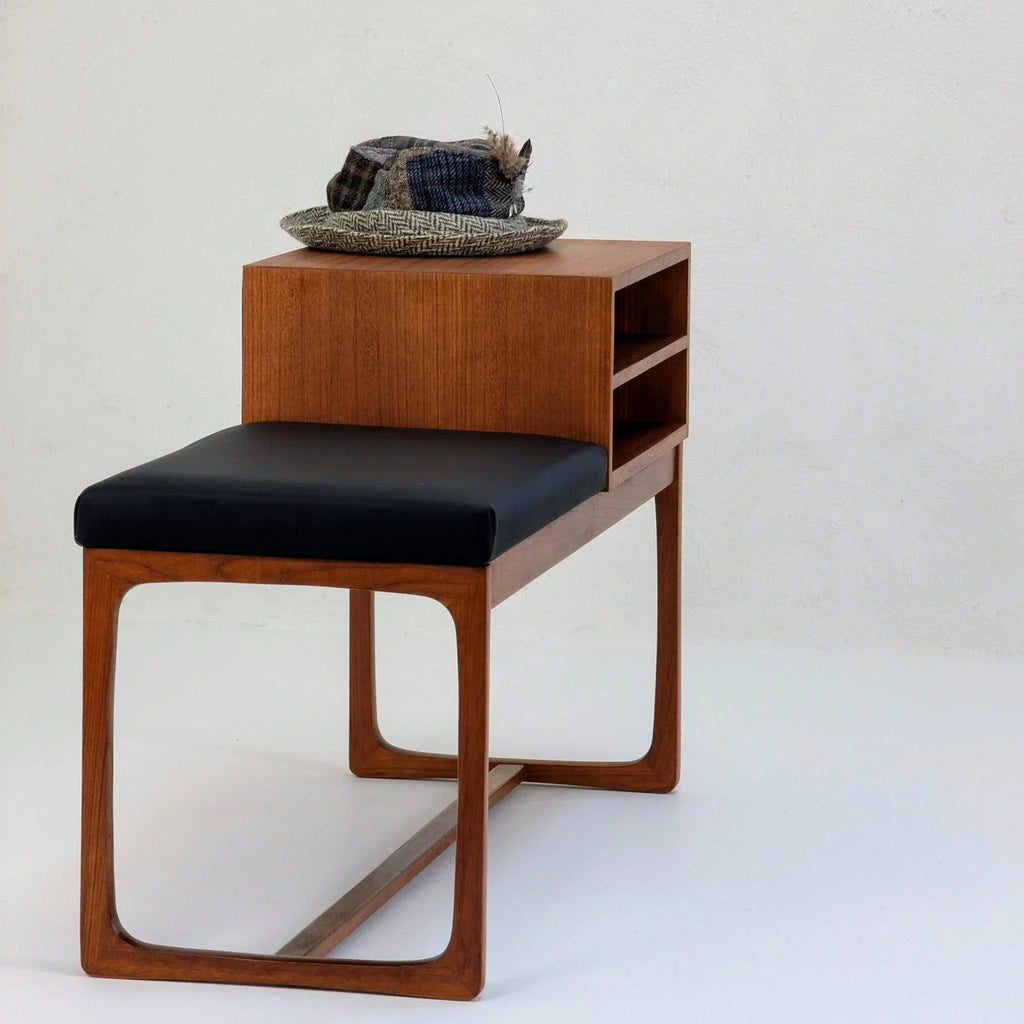 Mid-century teak telephone table with black seat cushion and shelves, hat on top