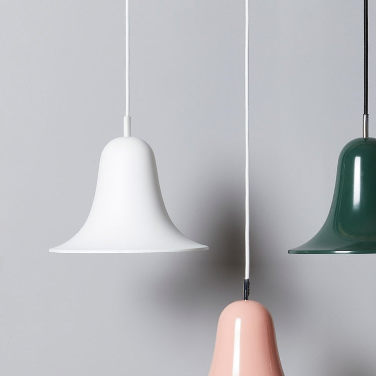 Three modern pendant light shades in white, dark green, and blush pink hanging from thin cords against a light gray background.