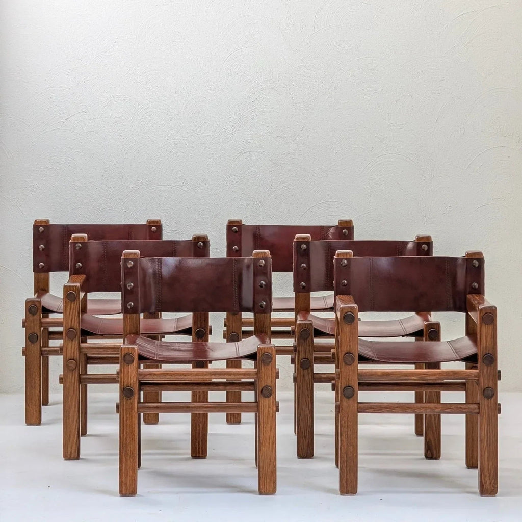 Set of six vintage 1970s brown leather and wood dining chairs on white background