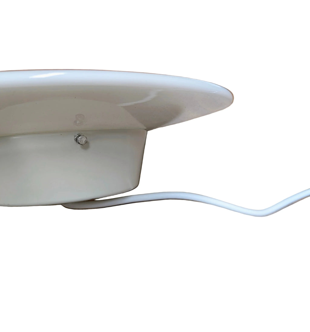 Close-up of white ceiling-mounted light fixture with power cable against white background
