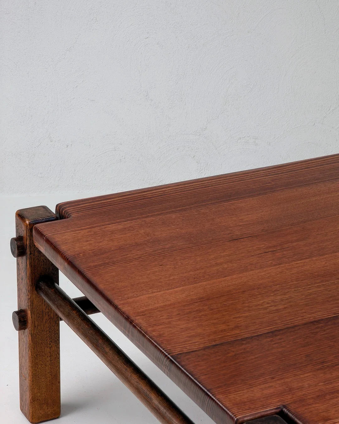 Close-up of smooth wooden table corner with dark brown grain and sturdy legs