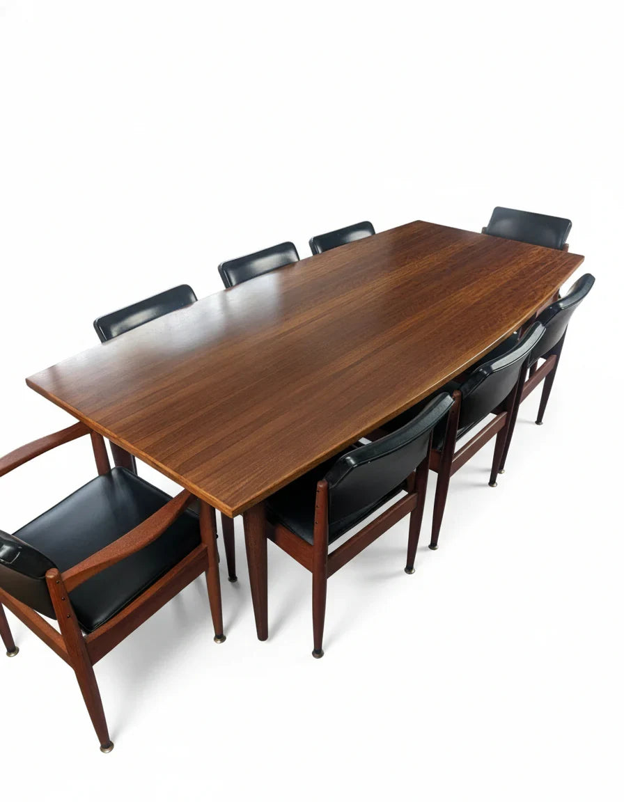 Rectangular wooden dining table with eight black leather chairs with wooden frames on white background