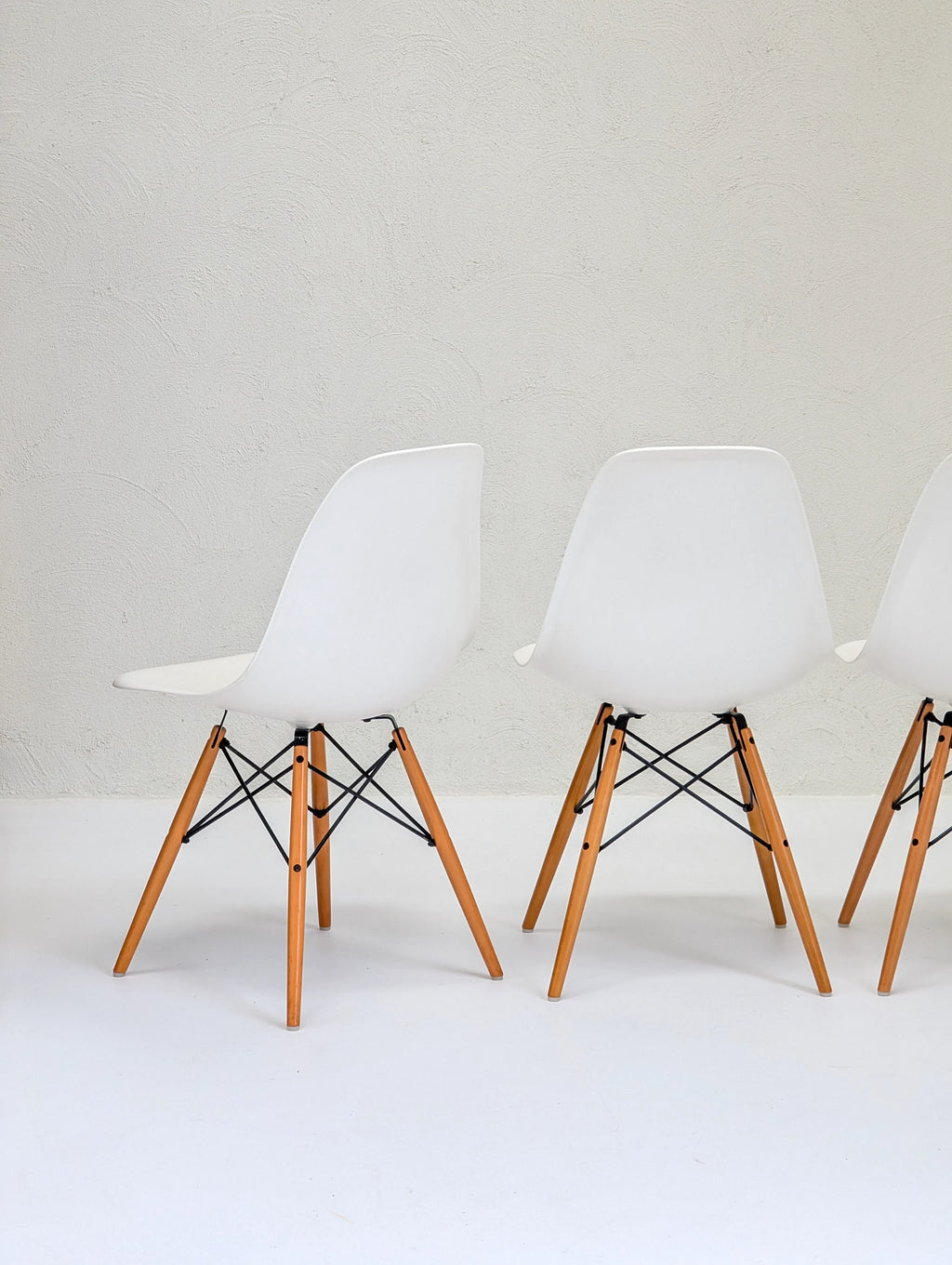 Modern white chairs with wooden legs on a minimalist white background