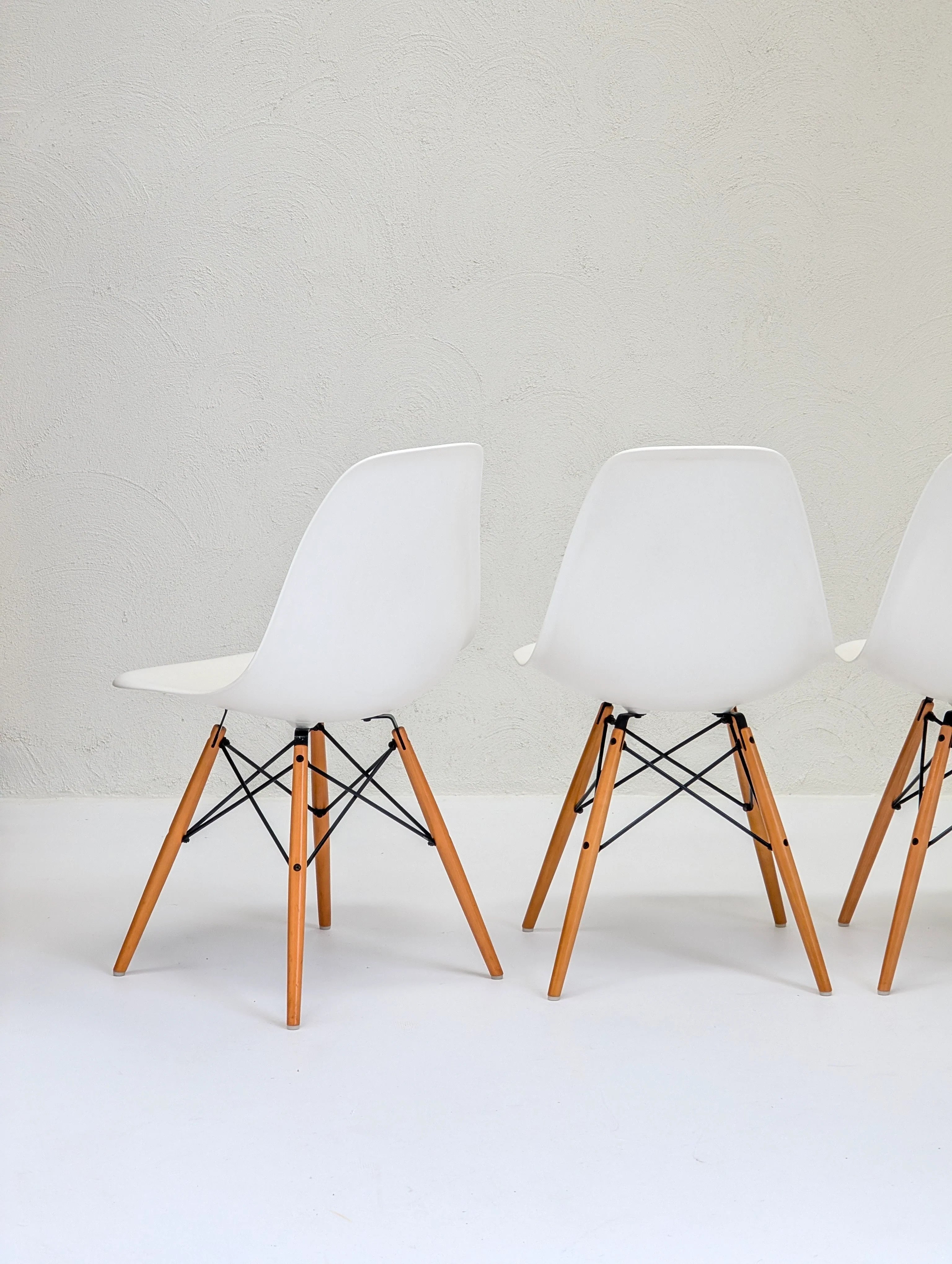 Modern white chairs with wooden legs on a minimalist white background