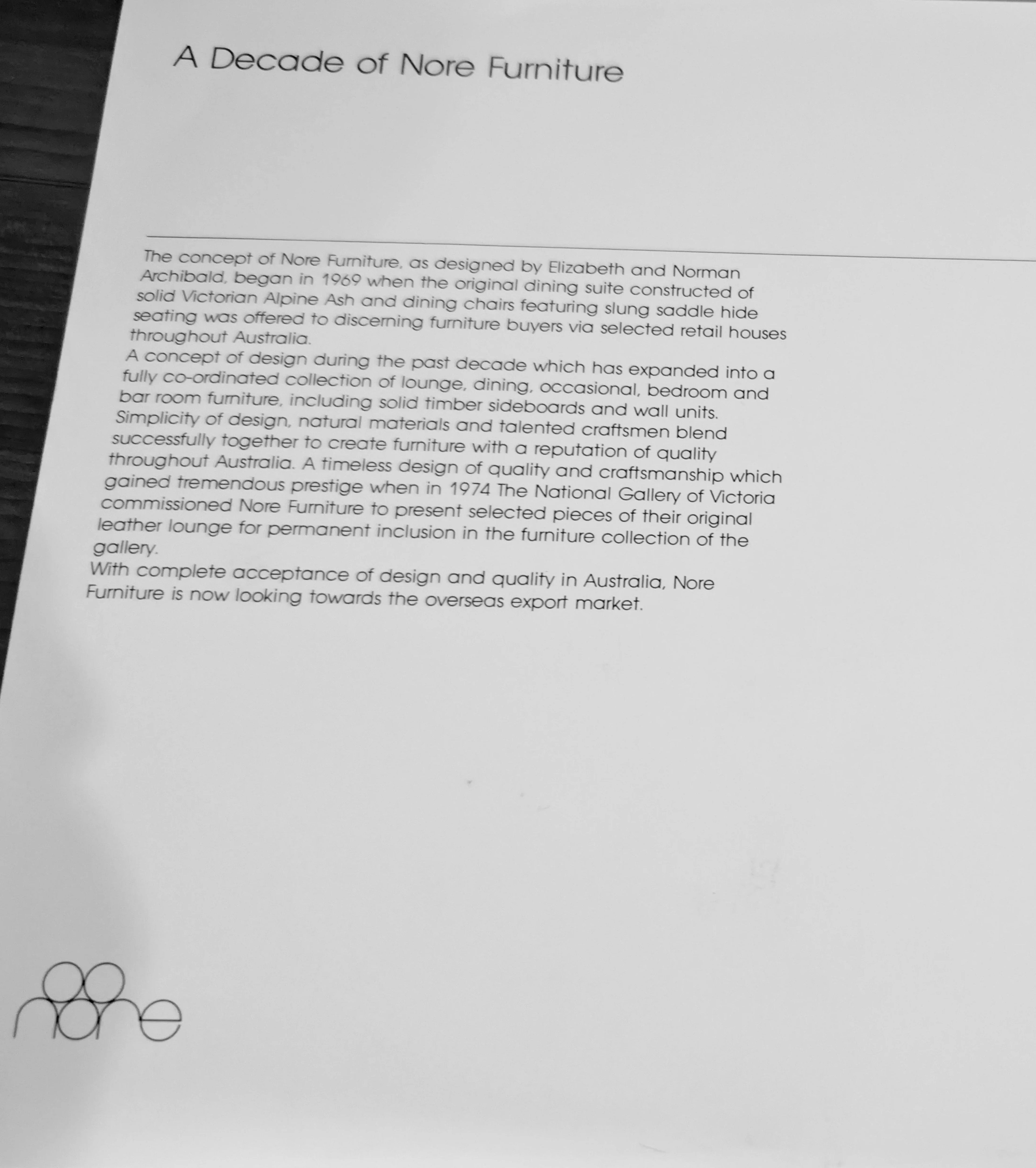 Black and white photo of a brochure page titled 'A Decade of Nore Furniture' with printed text and a Nore Furniture logo in the corner.