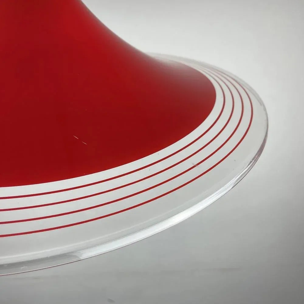 Close-up of a mid-century modern red and white ceramic or plastic dish with concentric red stripes