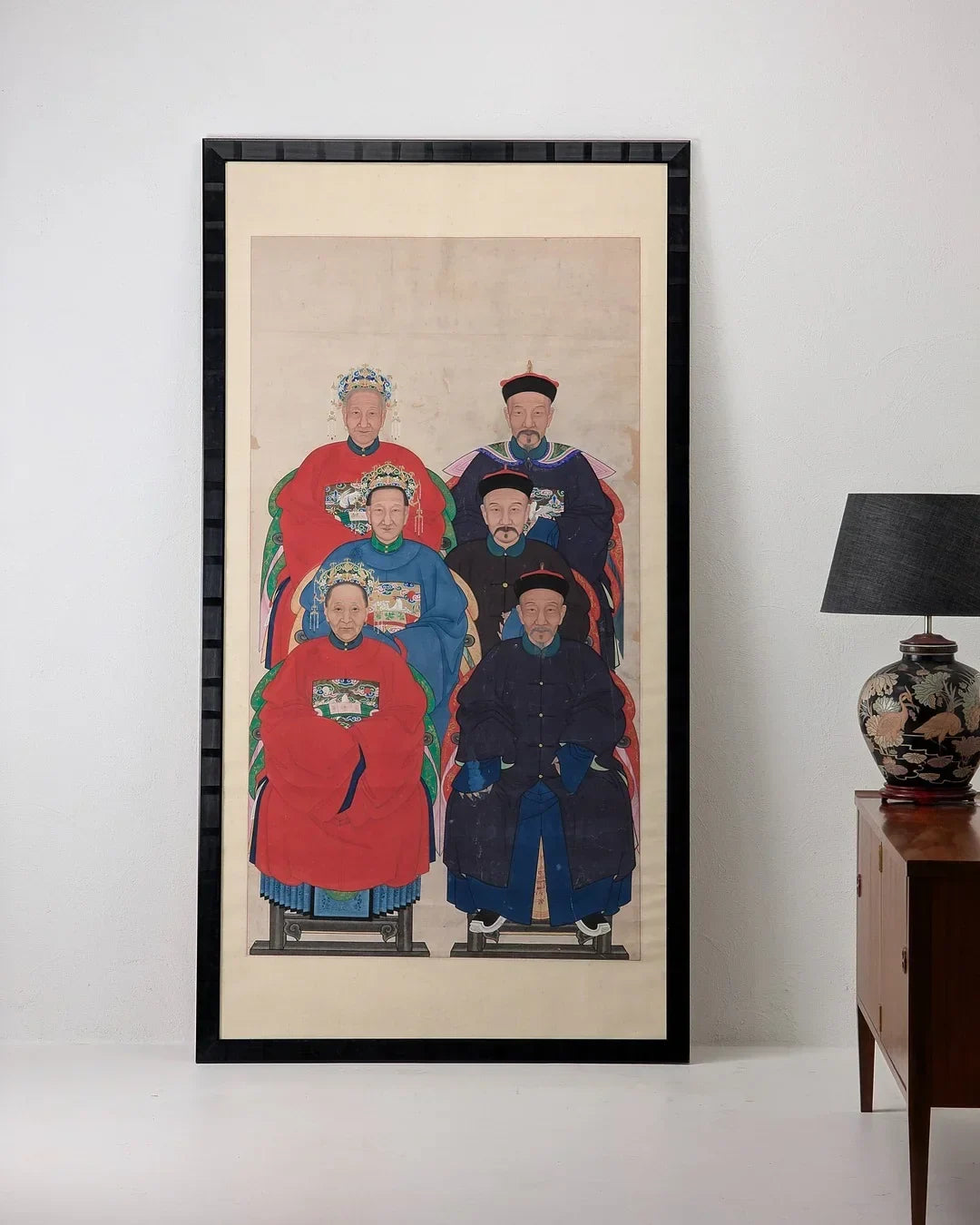 Framed Chinese ancestor portrait painting in a modern room with lamp and cabinet