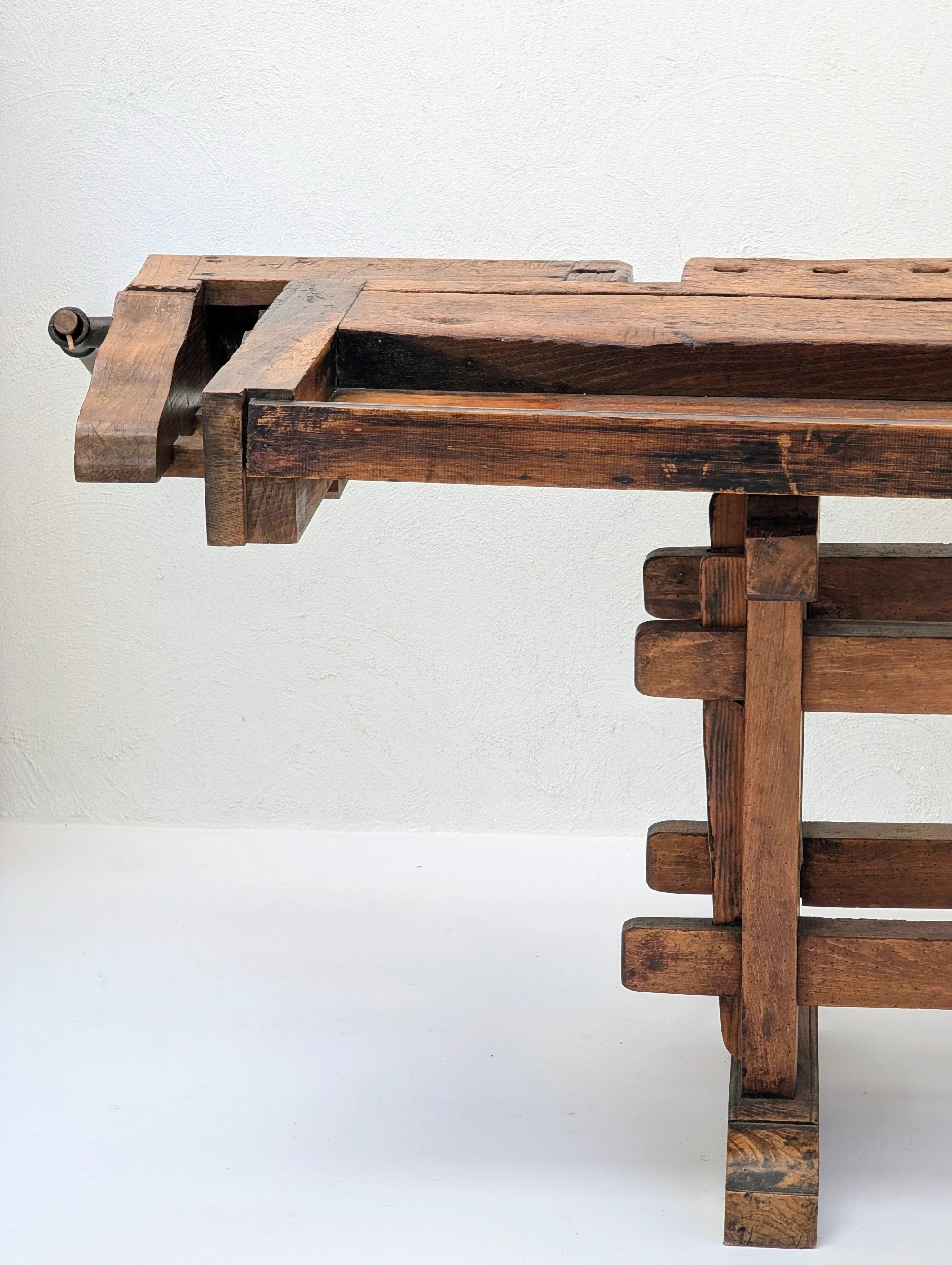 Vintage wooden workbench with vise on a white background, rustic woodworking table