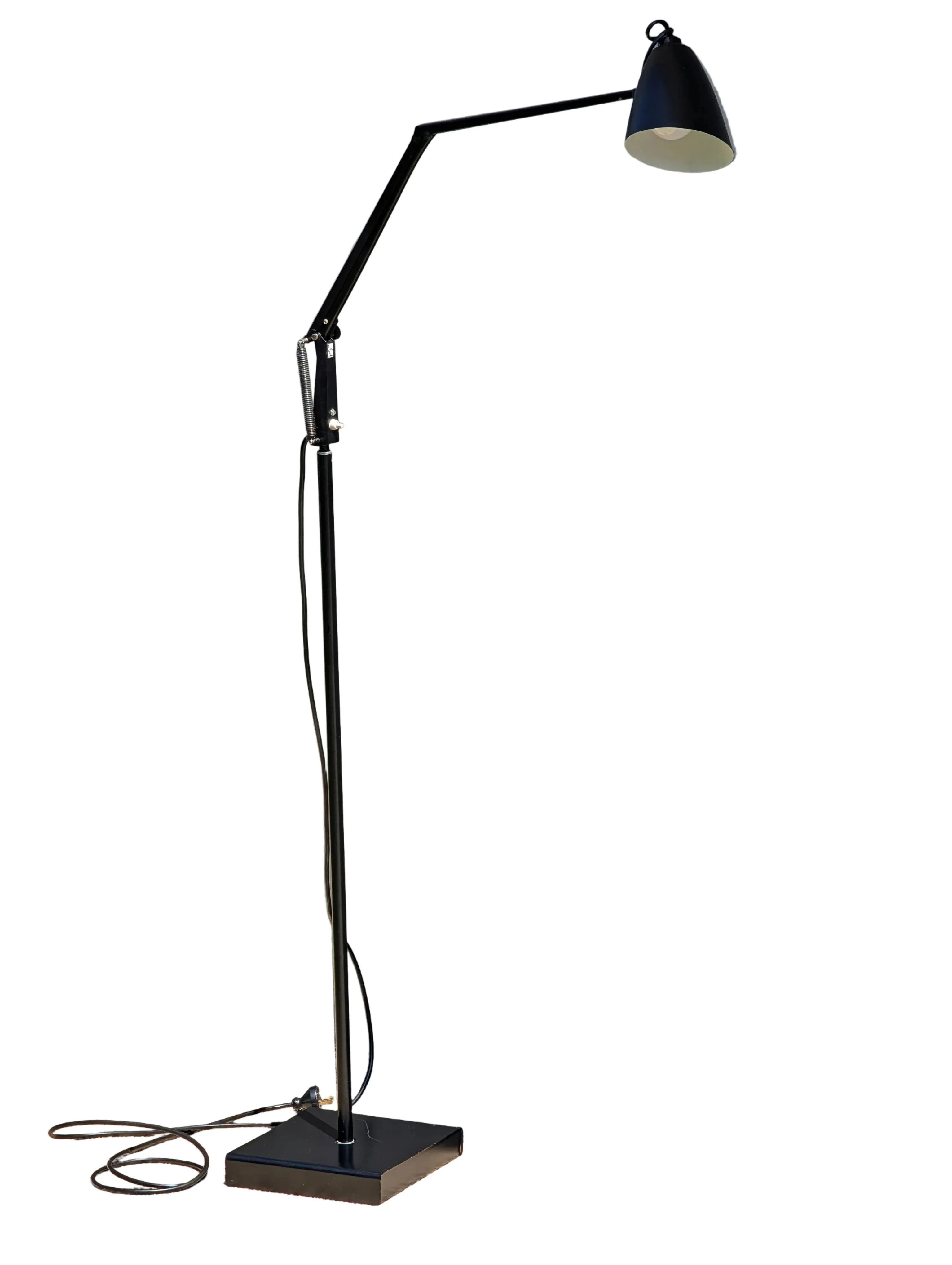 modern black adjustable floor lamp with angled arm and square base on white background