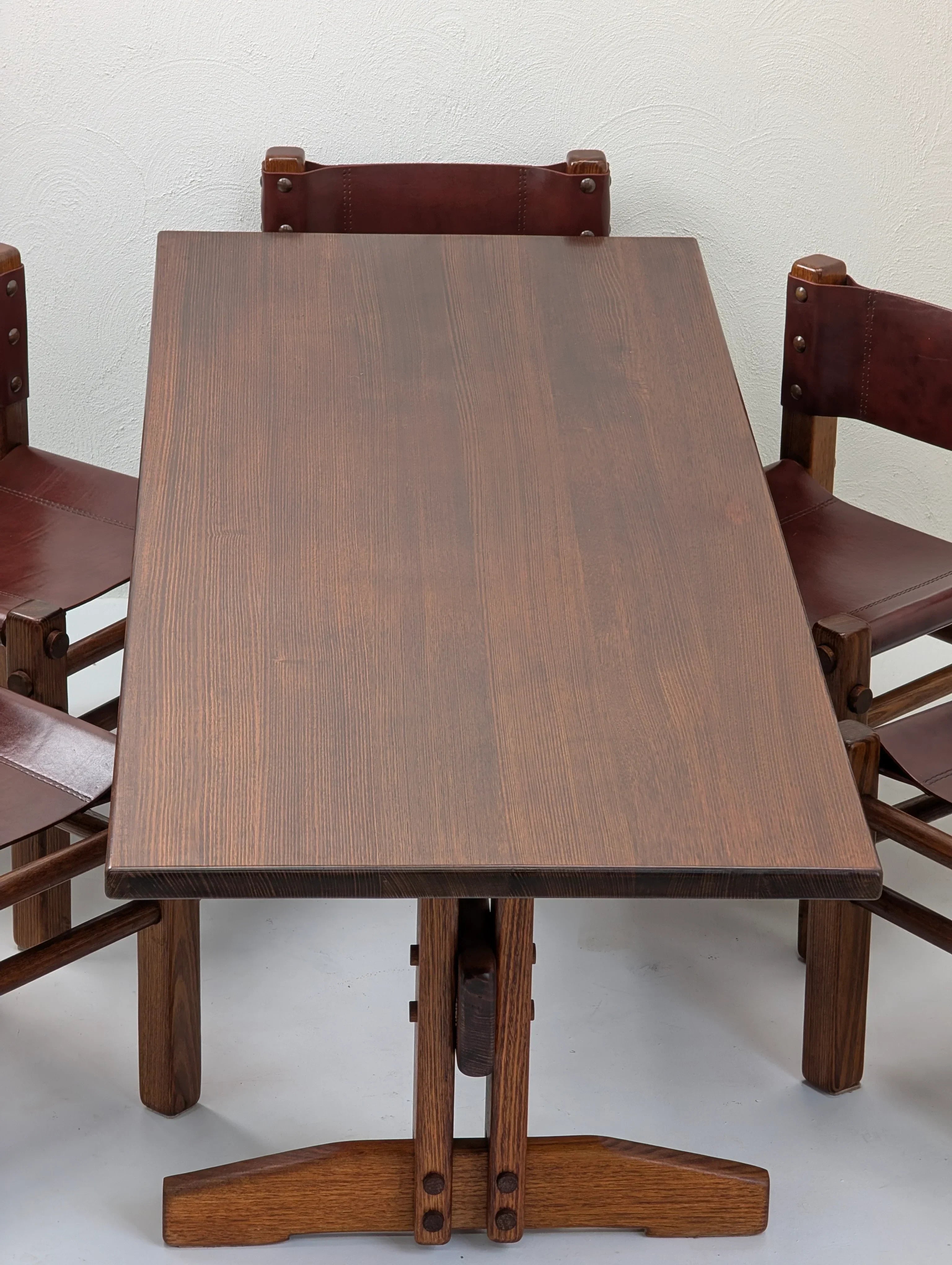 Rectangular dark wood dining table with three matching chairs and leather seats