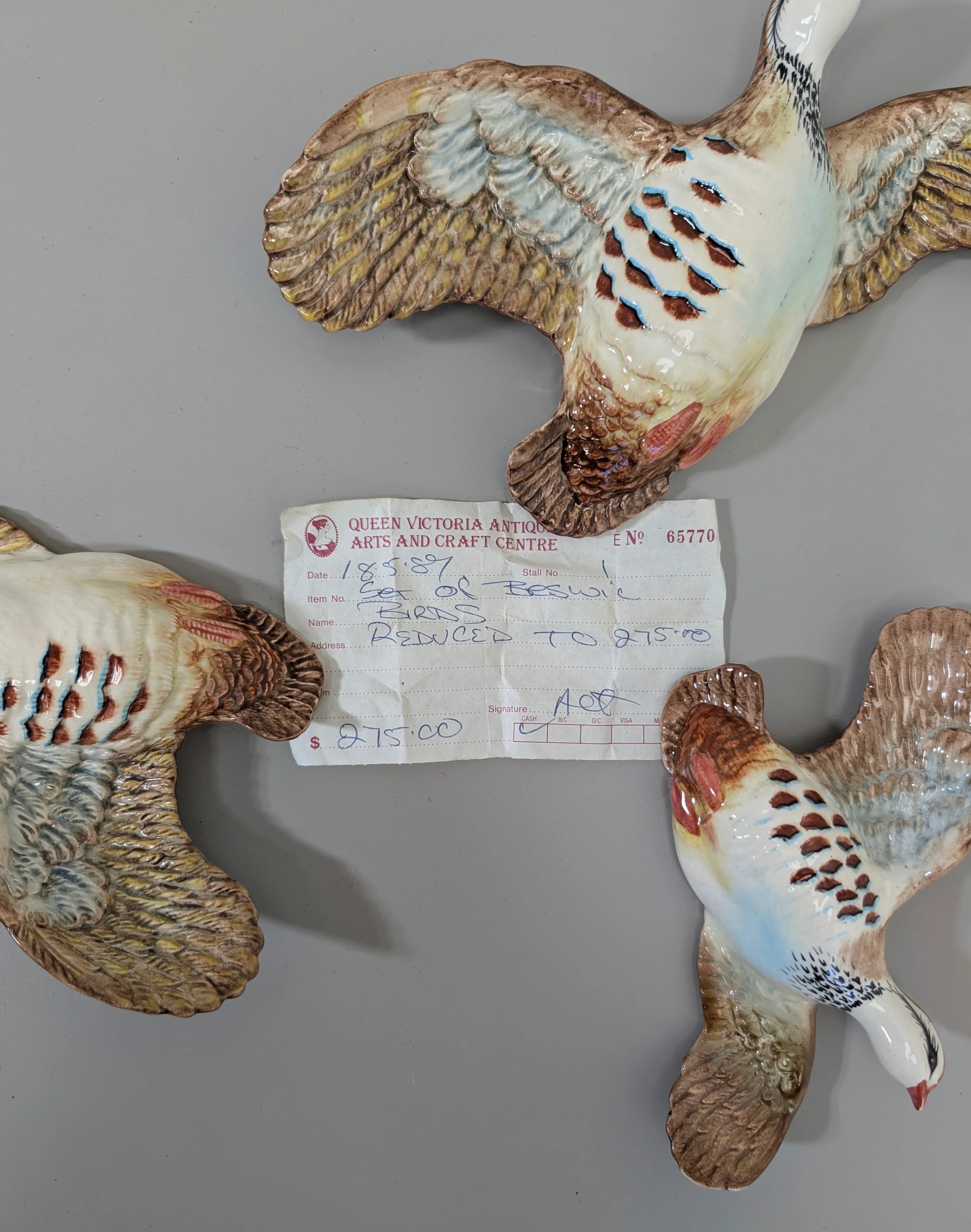 Ceramic flying bird wall decorations with an antique price tag showing $275