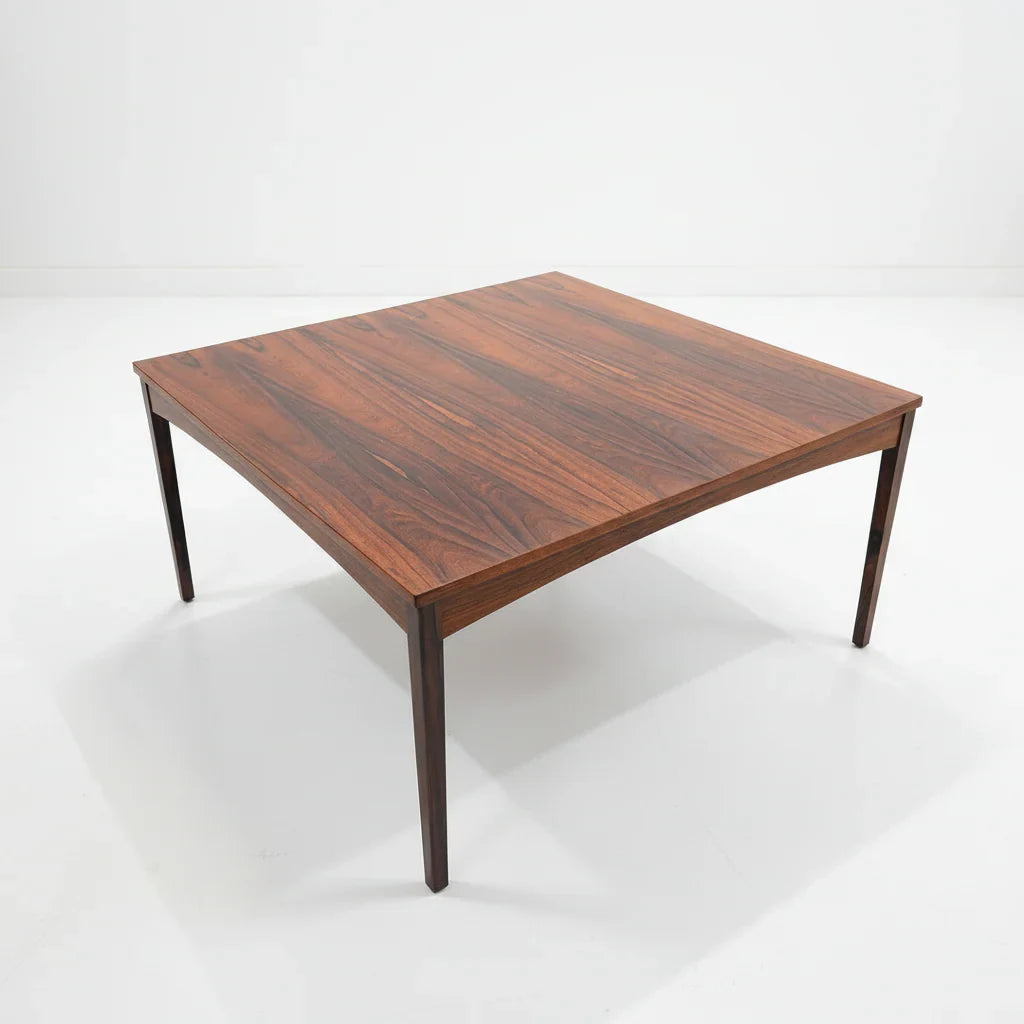 Mid-century modern square rosewood coffee table with tapered legs on a white background