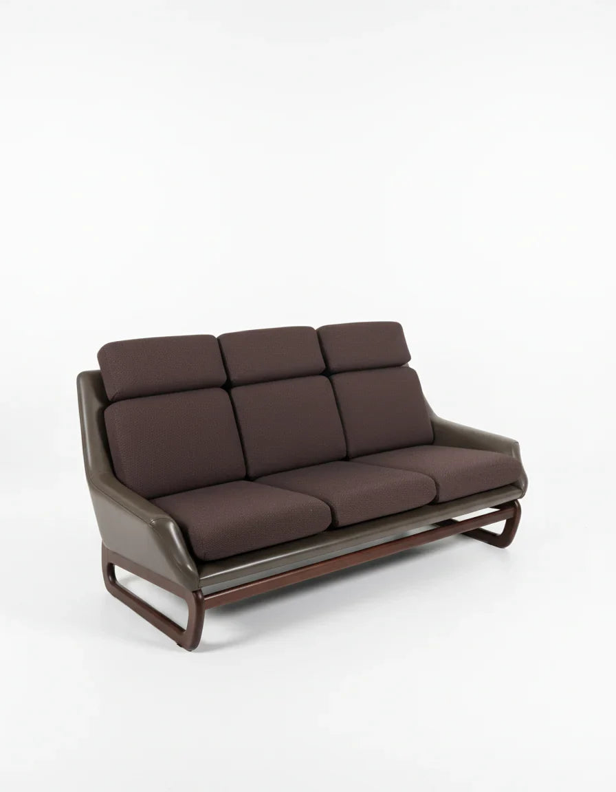 Modern three-seater sofa with brown fabric cushions and dark leather armrests on wooden base