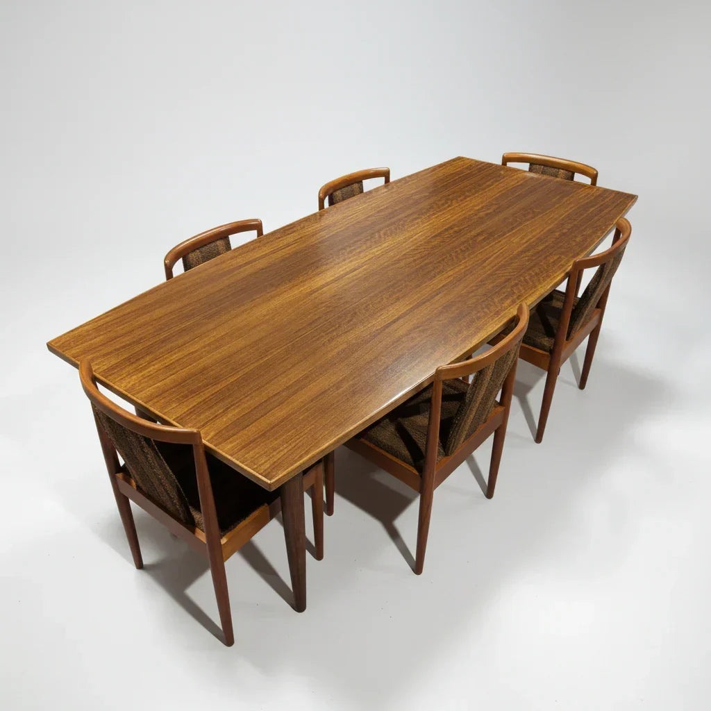 Mid-century modern teak dining table with six matching wood chairs in studio setting