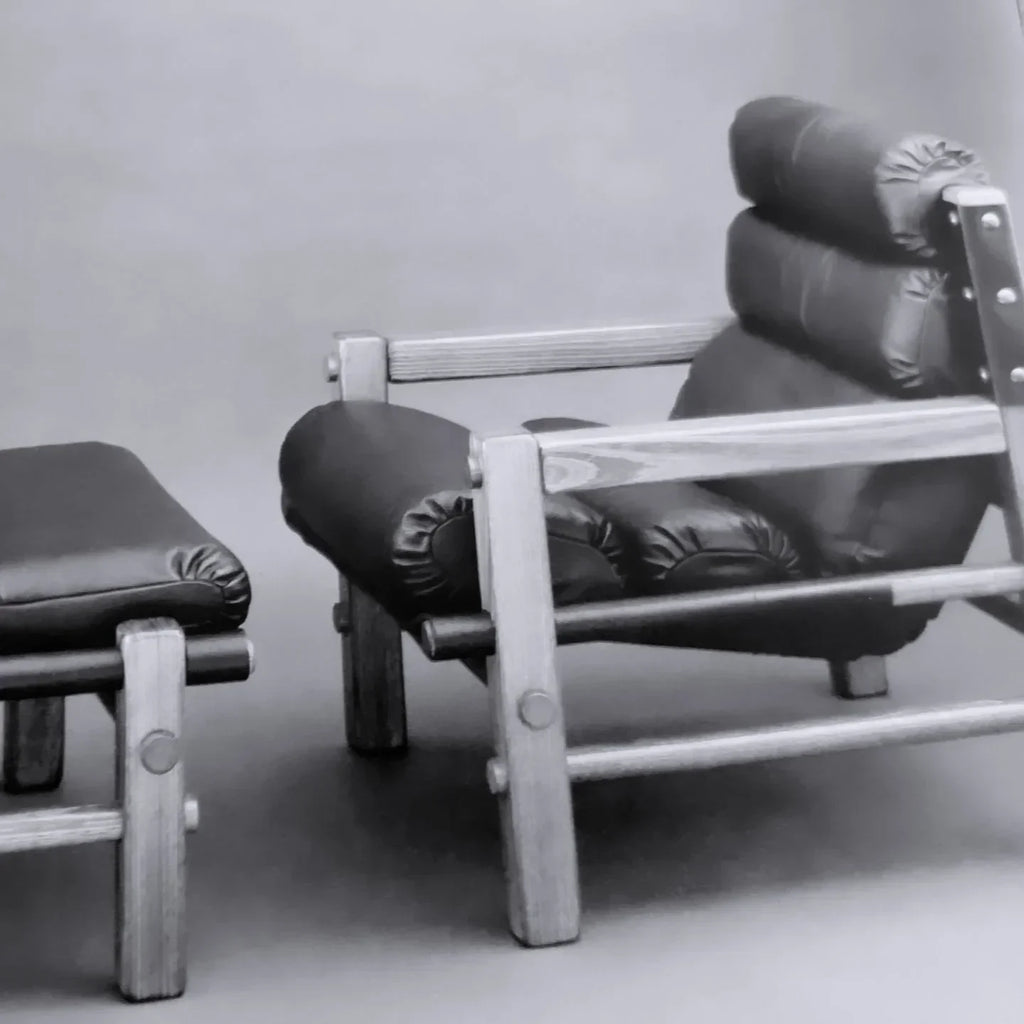 Modern wooden lounge chair with black leather cushion and matching ottoman