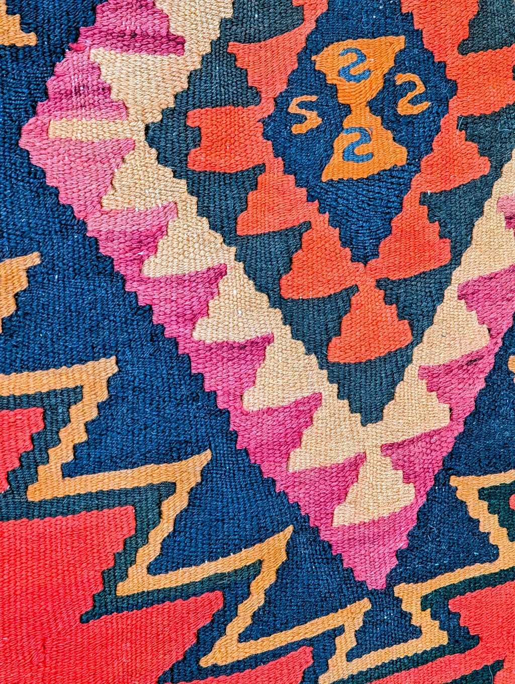Colorful geometric kilim rug pattern with red, blue, pink, and orange zigzag designs