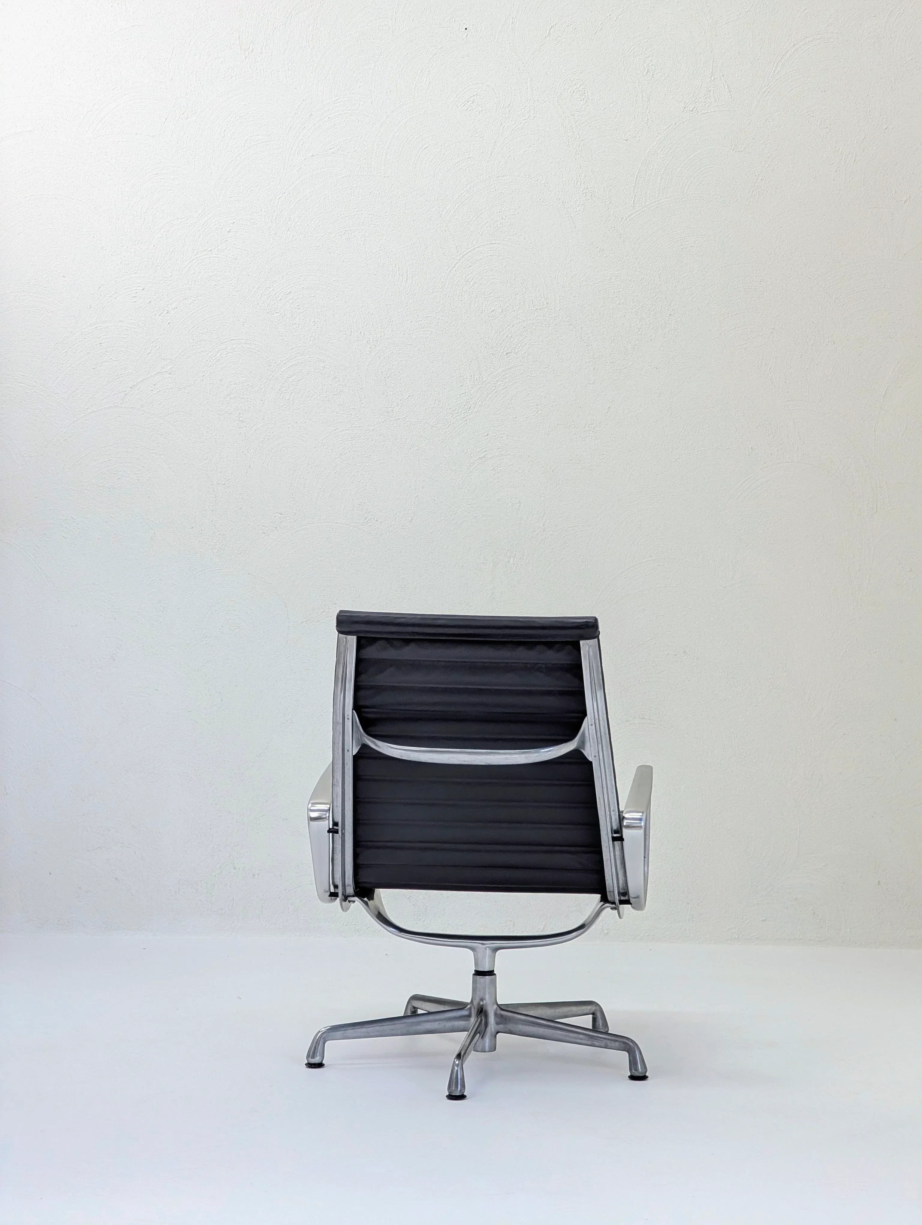 Modern black office chair with metal frame in minimal white room