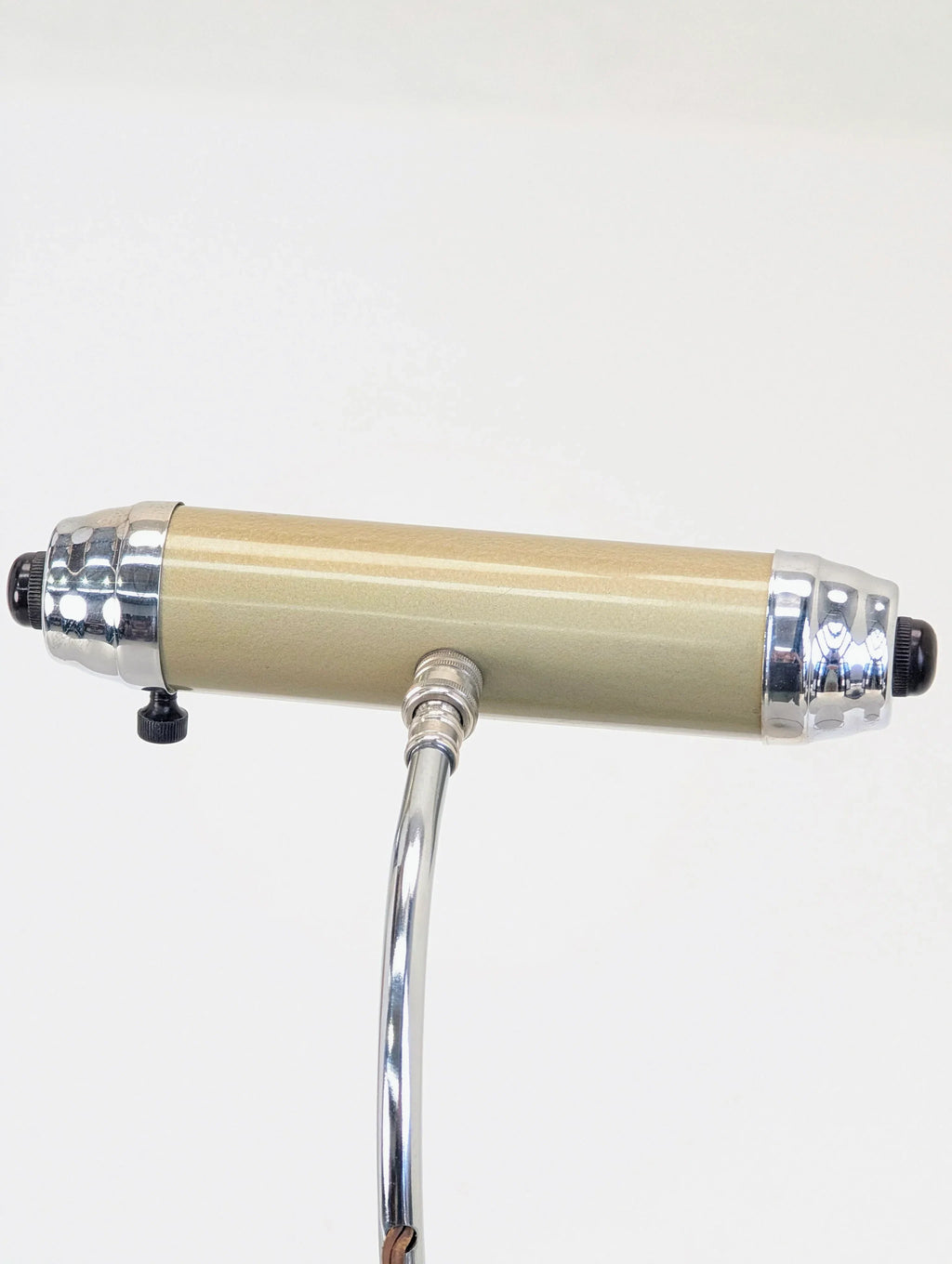 Vintage gold cylindrical microphone with chrome accents on a silver stand, white background