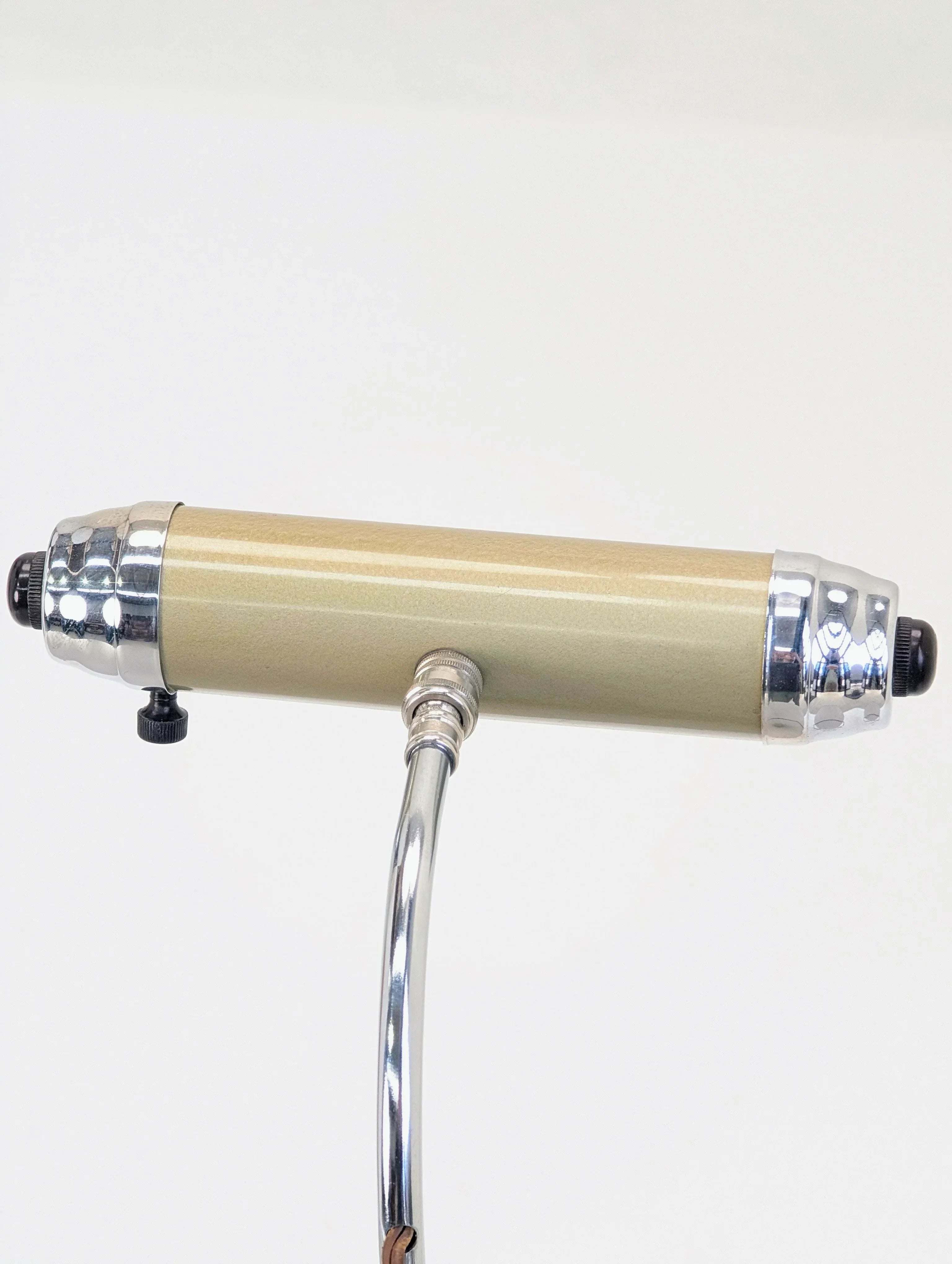 Vintage gold cylindrical microphone with chrome accents on a silver stand, white background