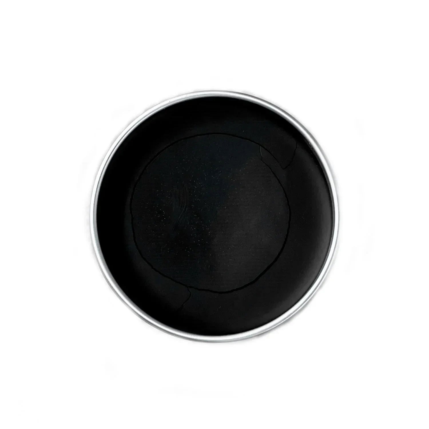 Top view of a round black balm in a tin container on a white background