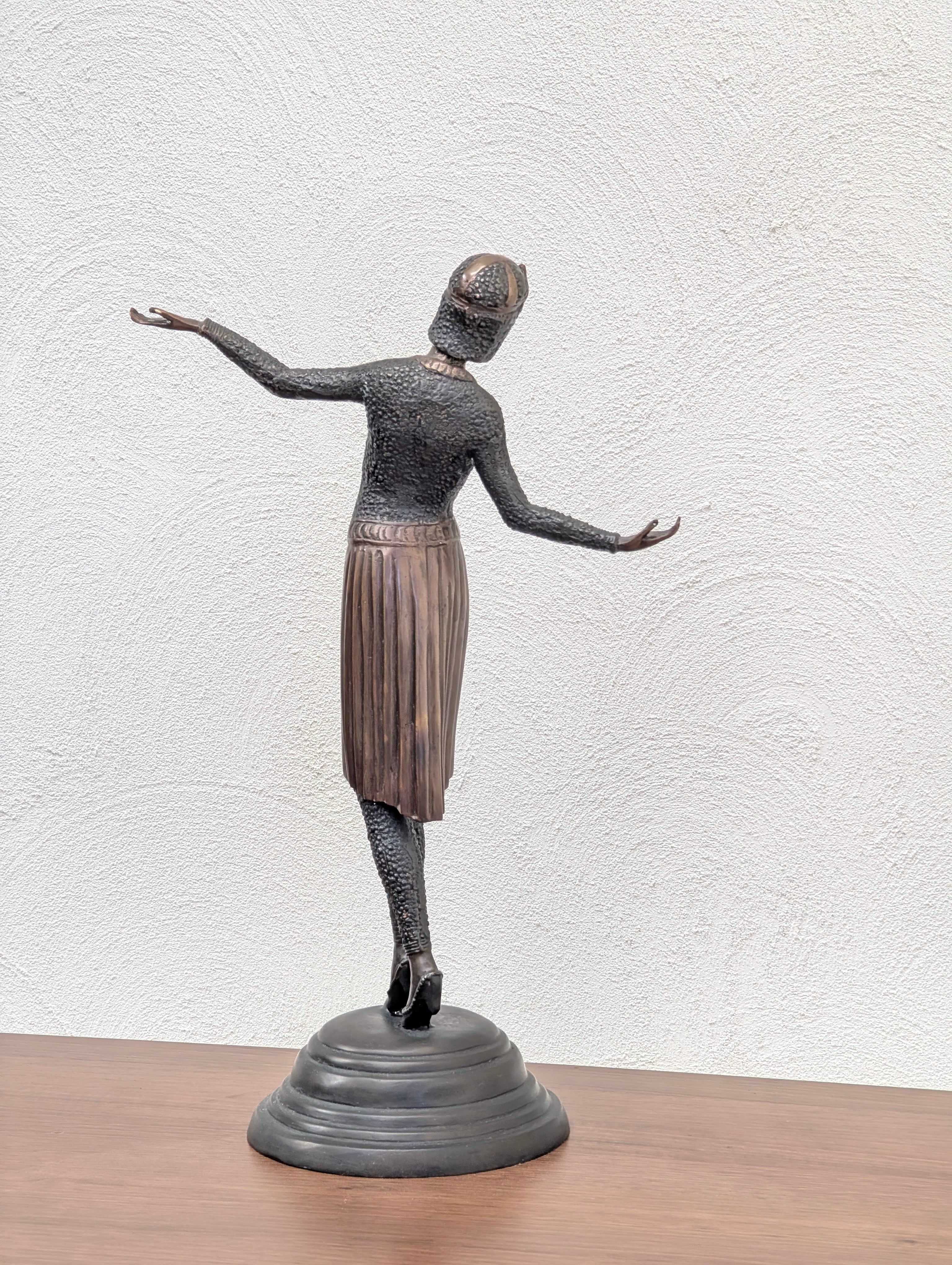 Bronze sculpture of a dancing woman in a textured dress and hat on a black round base