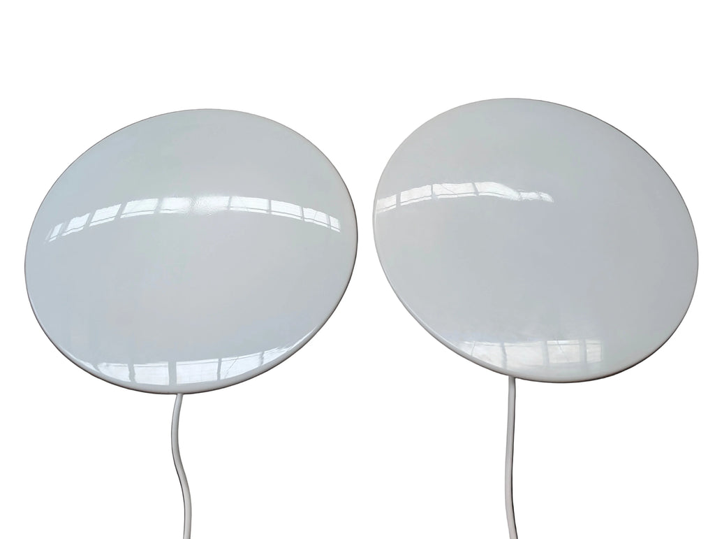 Two round white wireless indoor TV antennas with attached cables on a white background