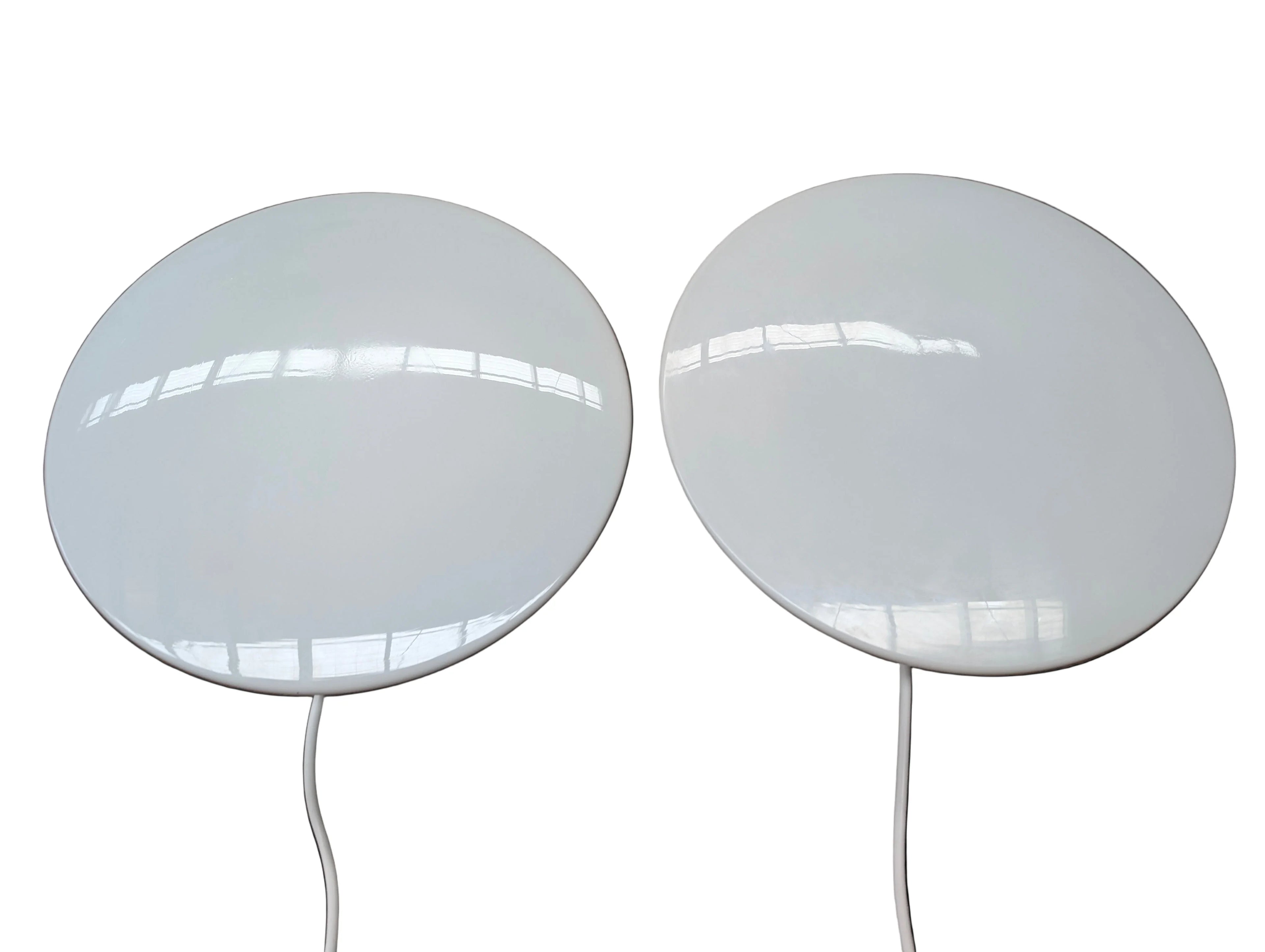 Two round white wireless indoor TV antennas with attached cables on a white background