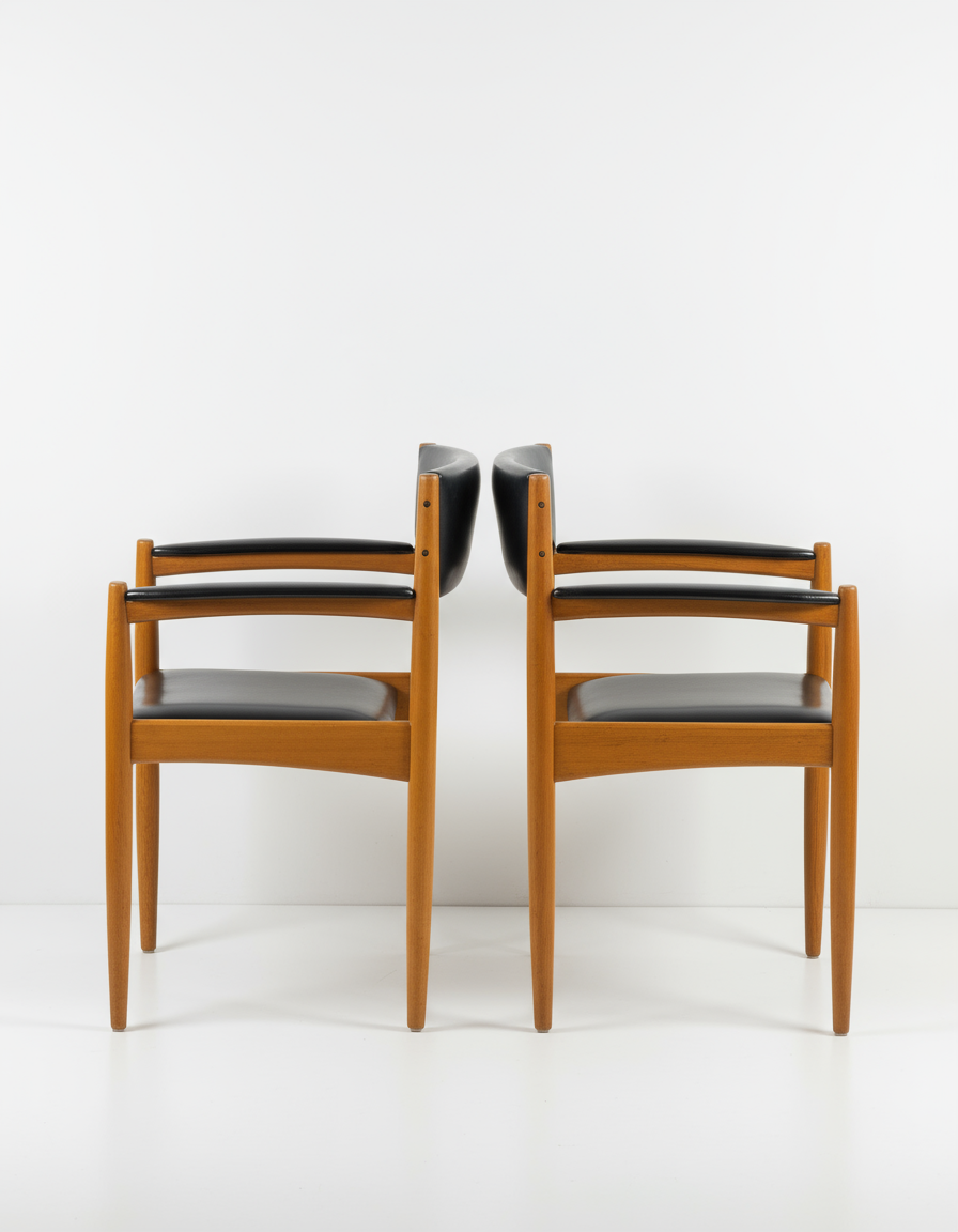 Pair of mid-century modern Danish teak armchairs with black leather seats and backs, minimalist design