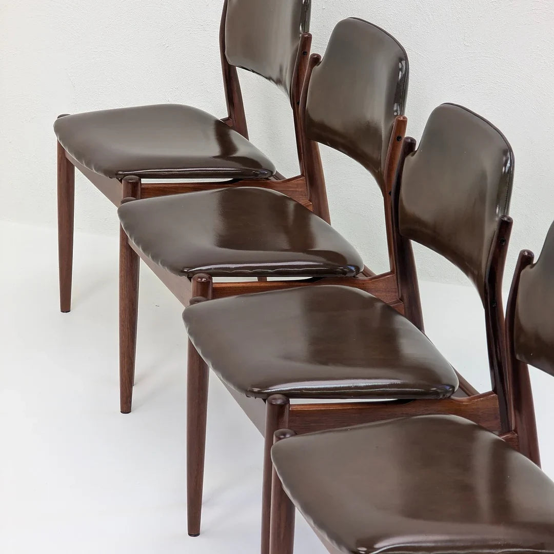 Set of vintage brown leather dining chairs with wooden legs on white background