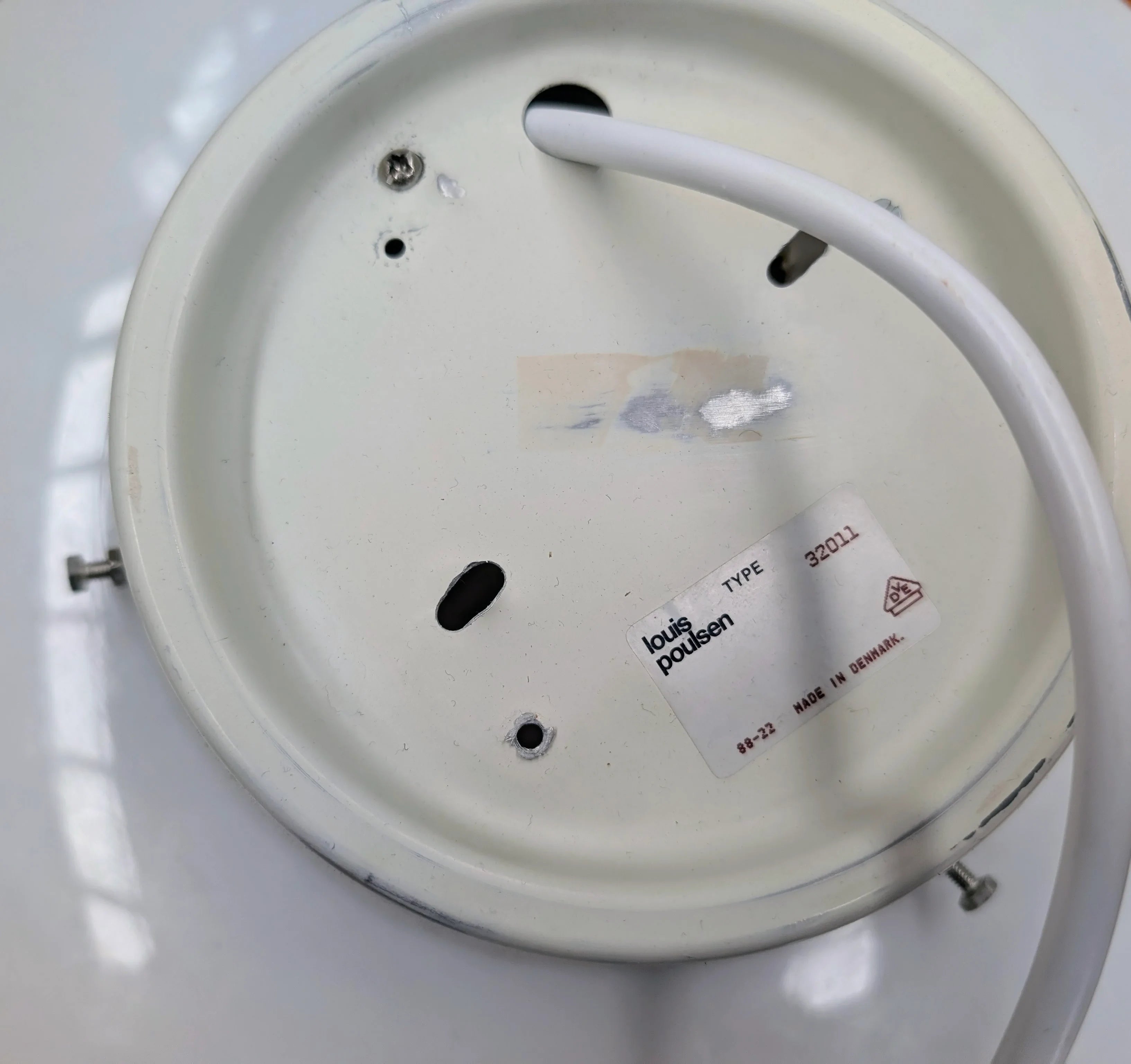 White circular metal base of Louis Poulsen lamp with cable and label, type 32011, made in Denmark