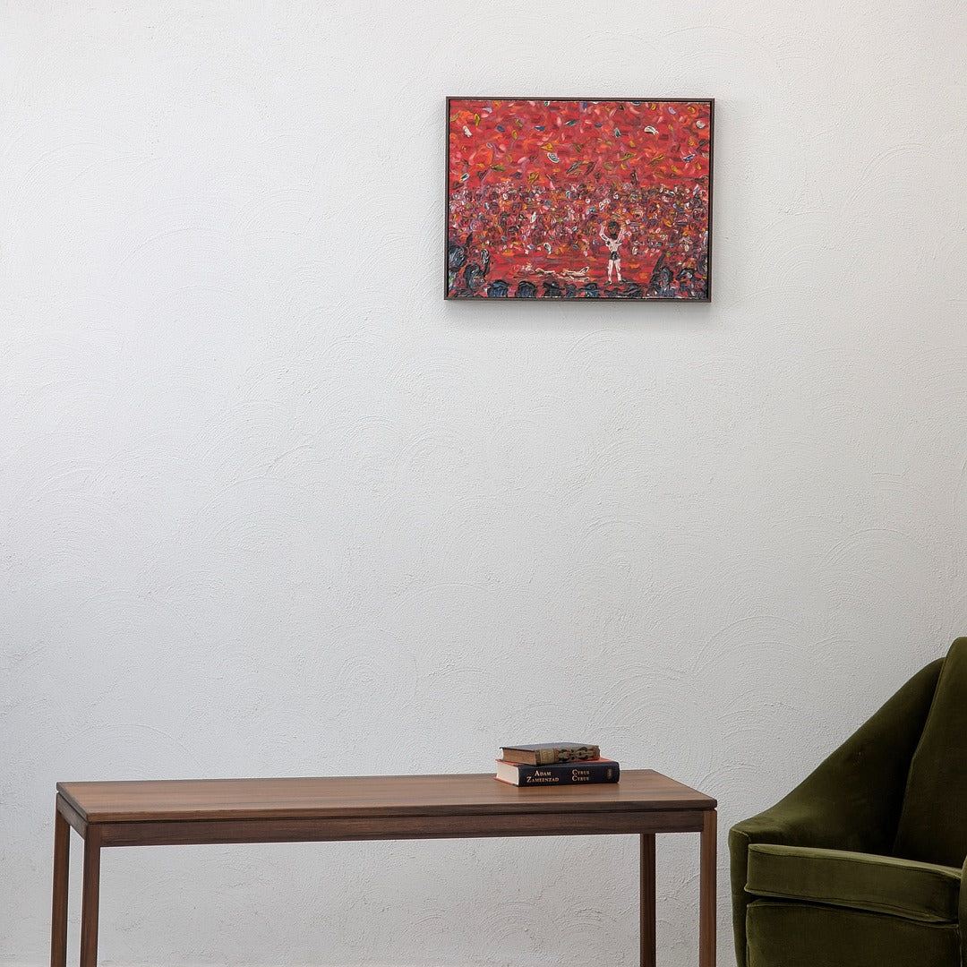 Red abstract wall art above wooden table with books and green velvet chair in modern living room