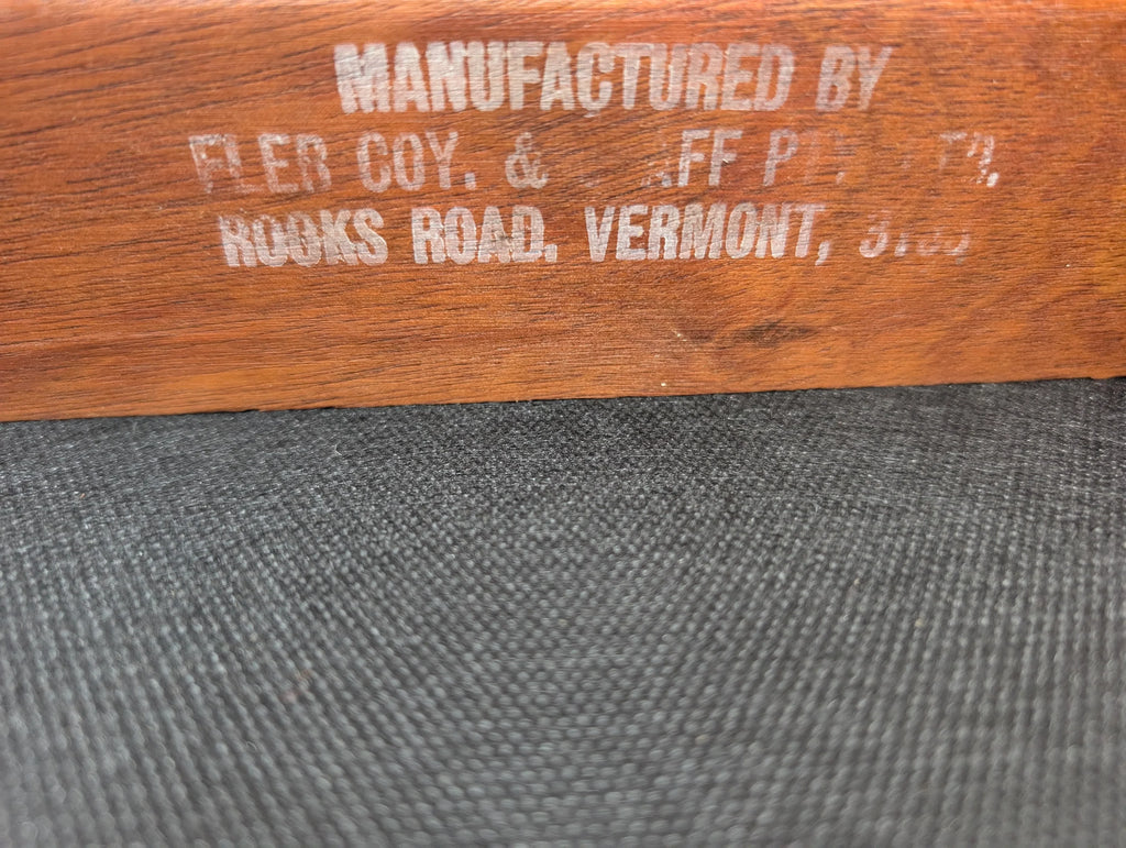 Stamped text on wooden surface showing manufacturer details, Vermont, rustic wood texture