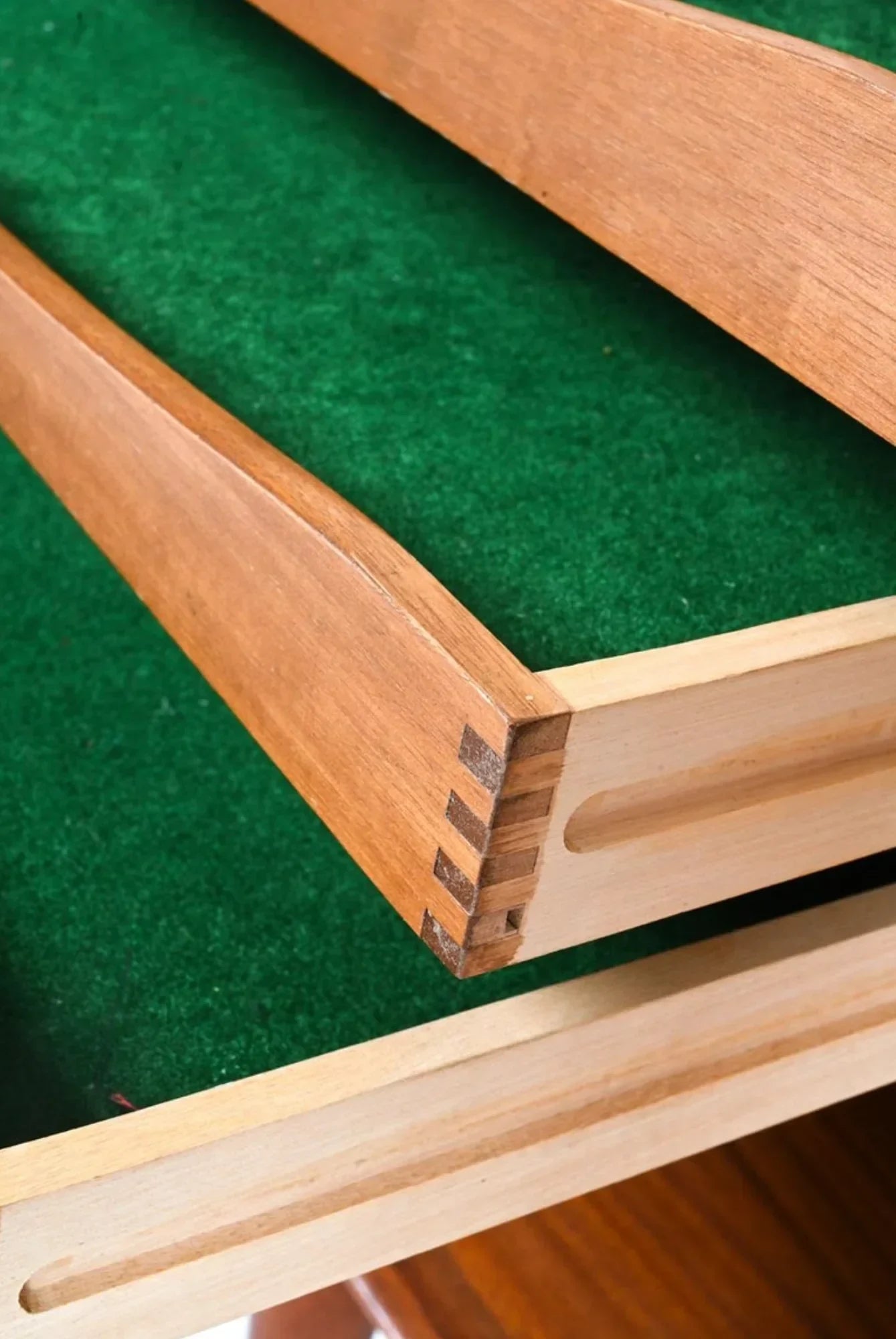 Dovetail joint wooden drawer with green felt lining, close-up furniture detail