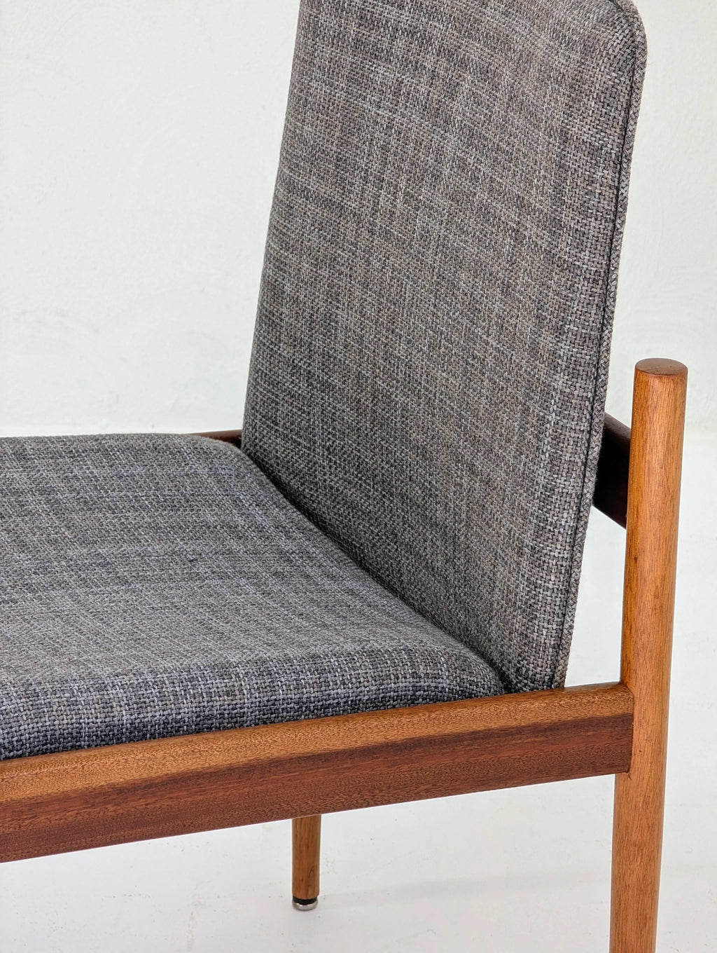 Close-up of gray upholstered seat and backrest with wooden frame of modern chair