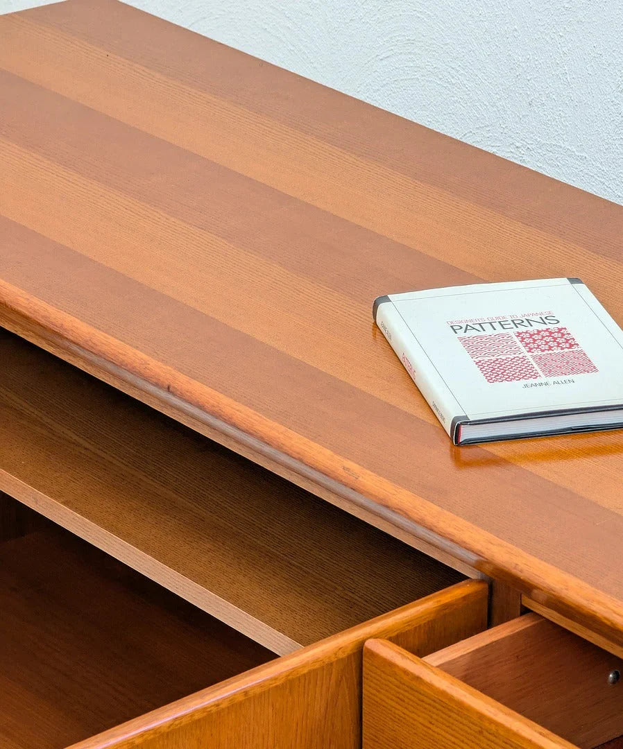 Wooden desk with open drawer and a book titled 'Japanese Patterns' on top