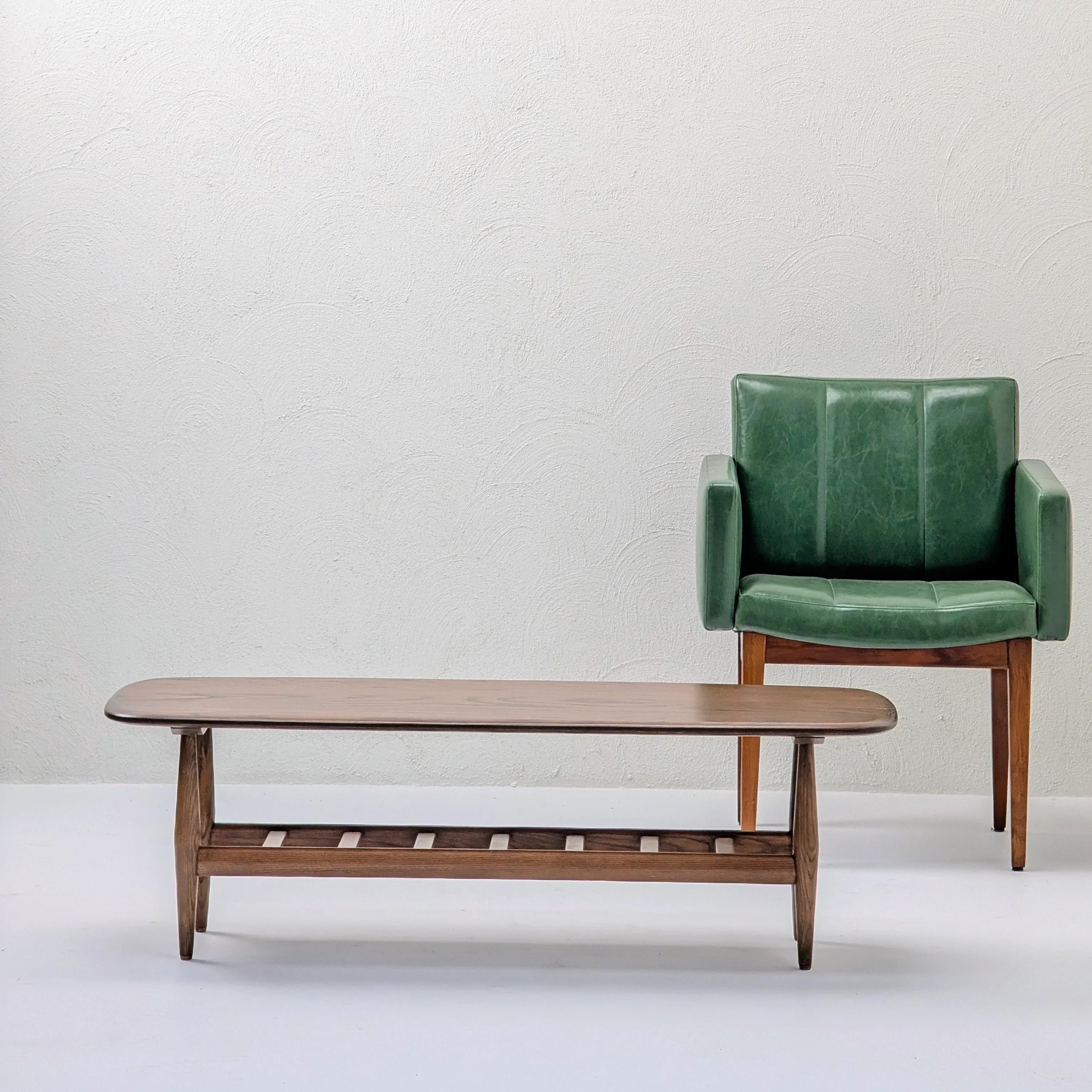 Mid-century modern wood coffee table and green armchair in minimalist room