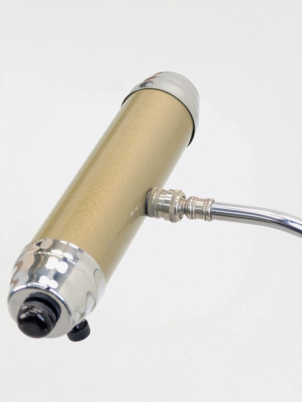 Gold and chrome handheld tattoo machine on white background