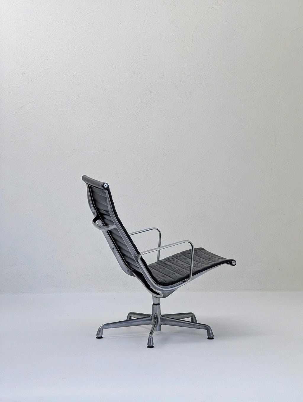 Modern gray office chair with metal frame in minimalist empty room