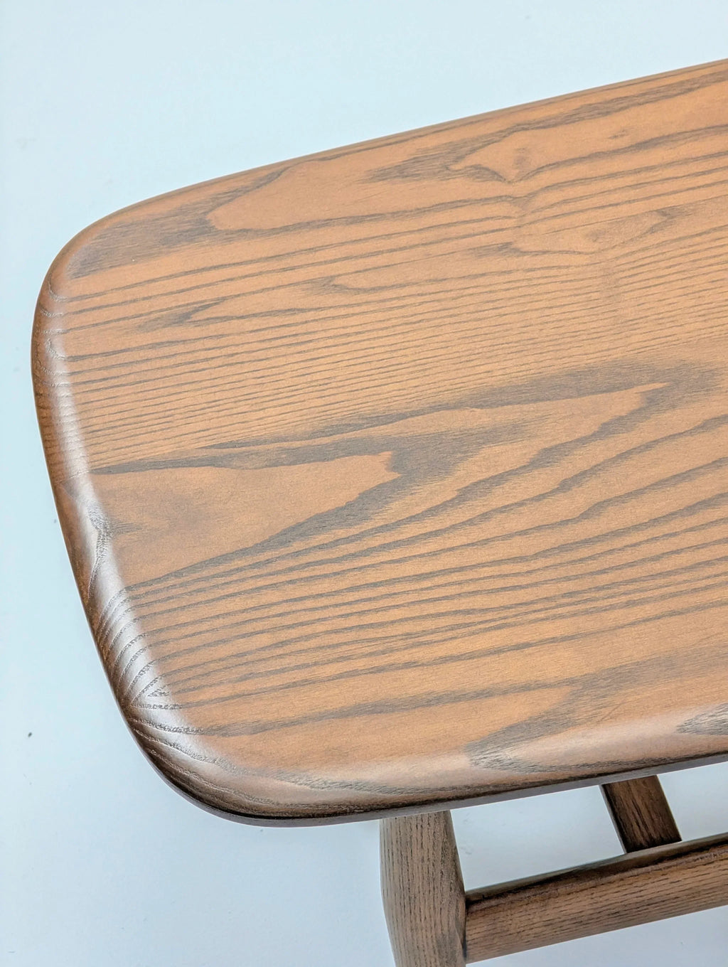 Close-up of a wooden table top with natural wood grain on a light background
