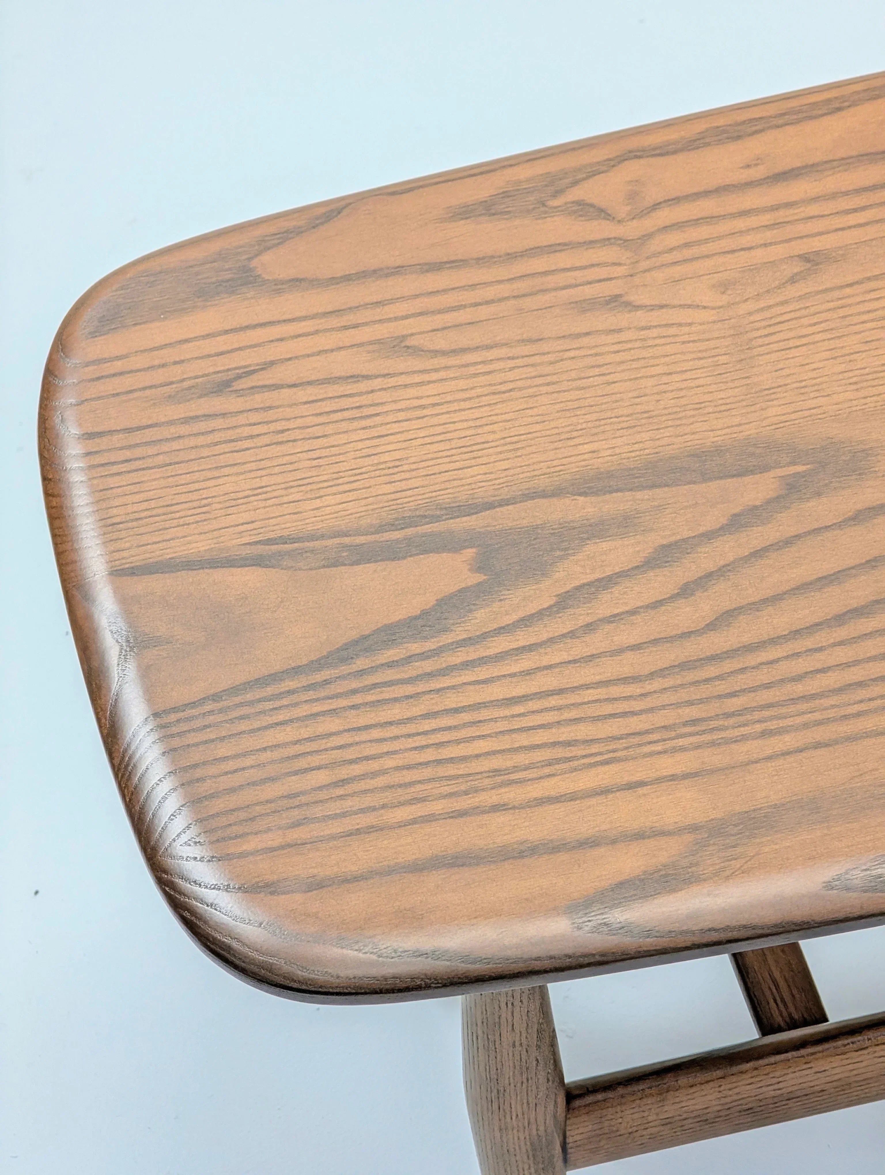 Close-up of a wooden table top with natural wood grain on a light background