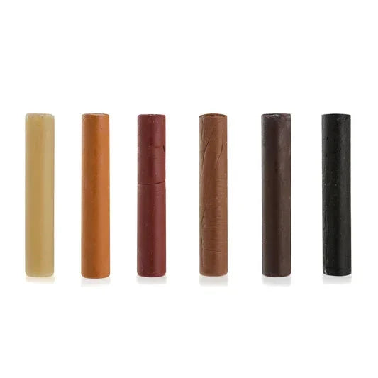 Set of six furniture touch up wax sticks in assorted wood colors on white background
