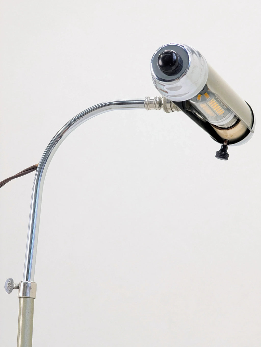 Vintage chrome gooseneck lamp with cylindrical shade against a plain background