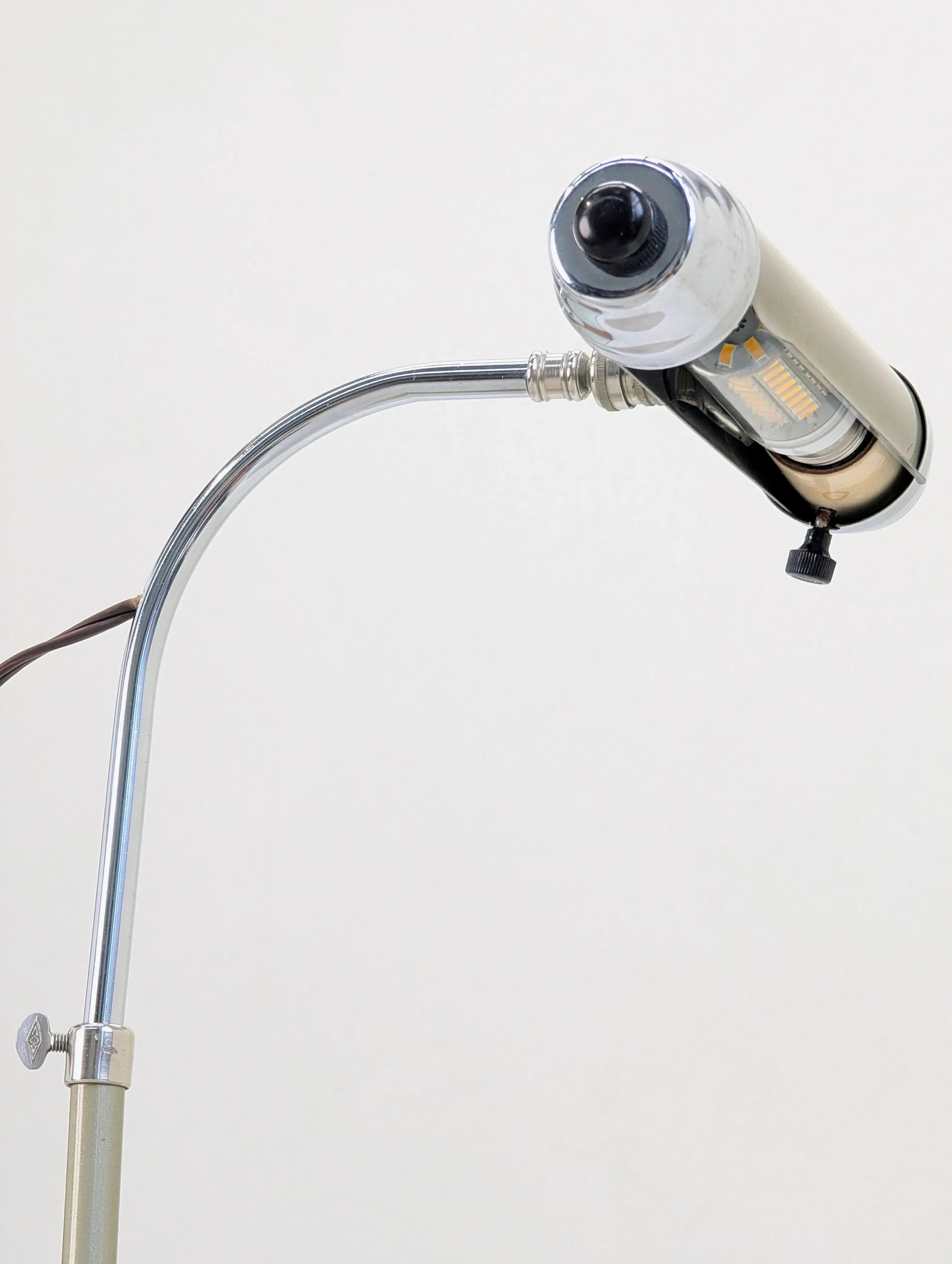 Vintage chrome gooseneck lamp with cylindrical shade against a plain background